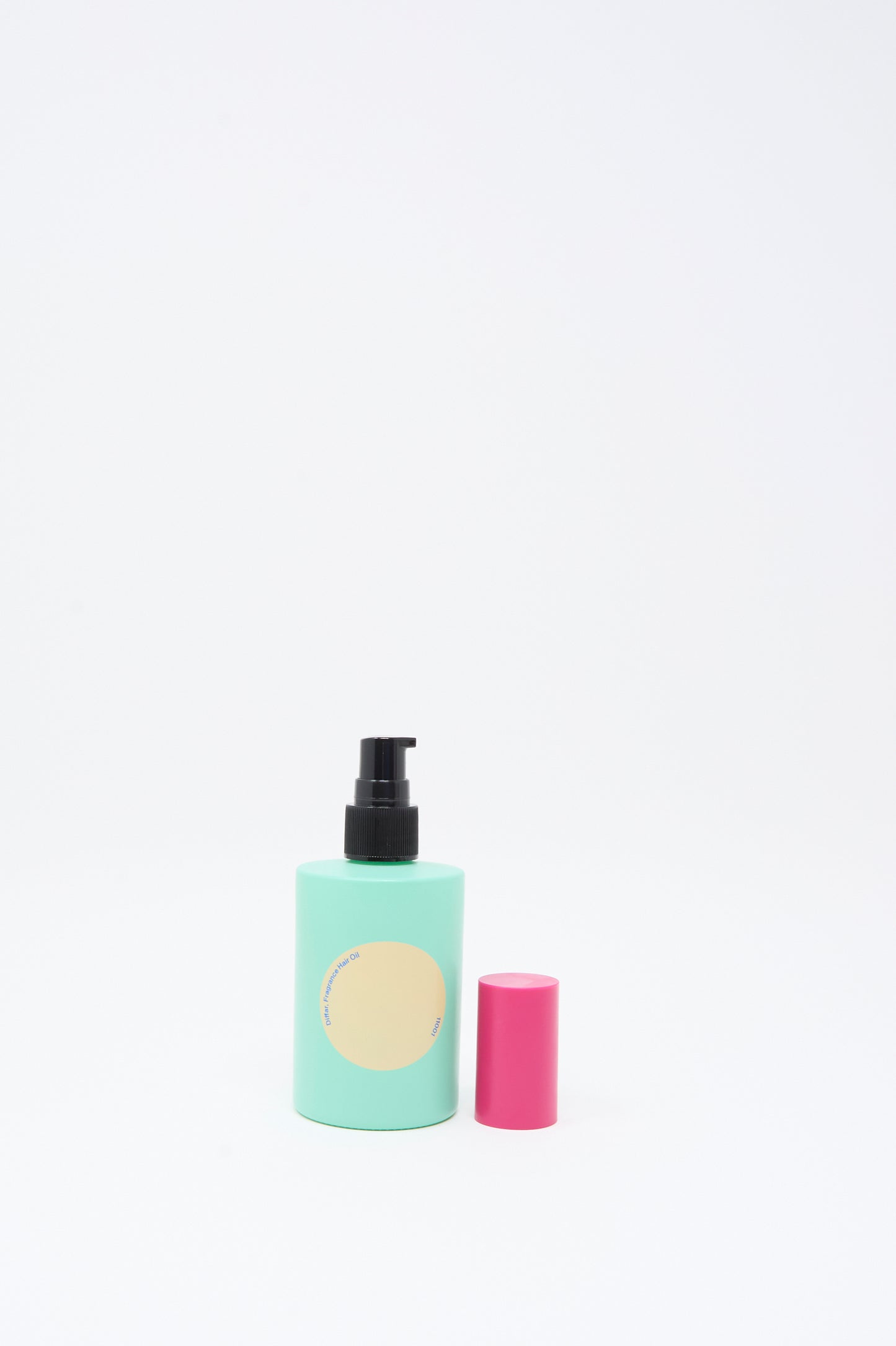 A light green pump bottle of Diffar's Tokyo Balance Fragrance Oil, featuring a blank beige label and a detached pink cap placed beside it, set against a plain white background—perfect for storing this plant-based essential oil-infused hair fragrance.