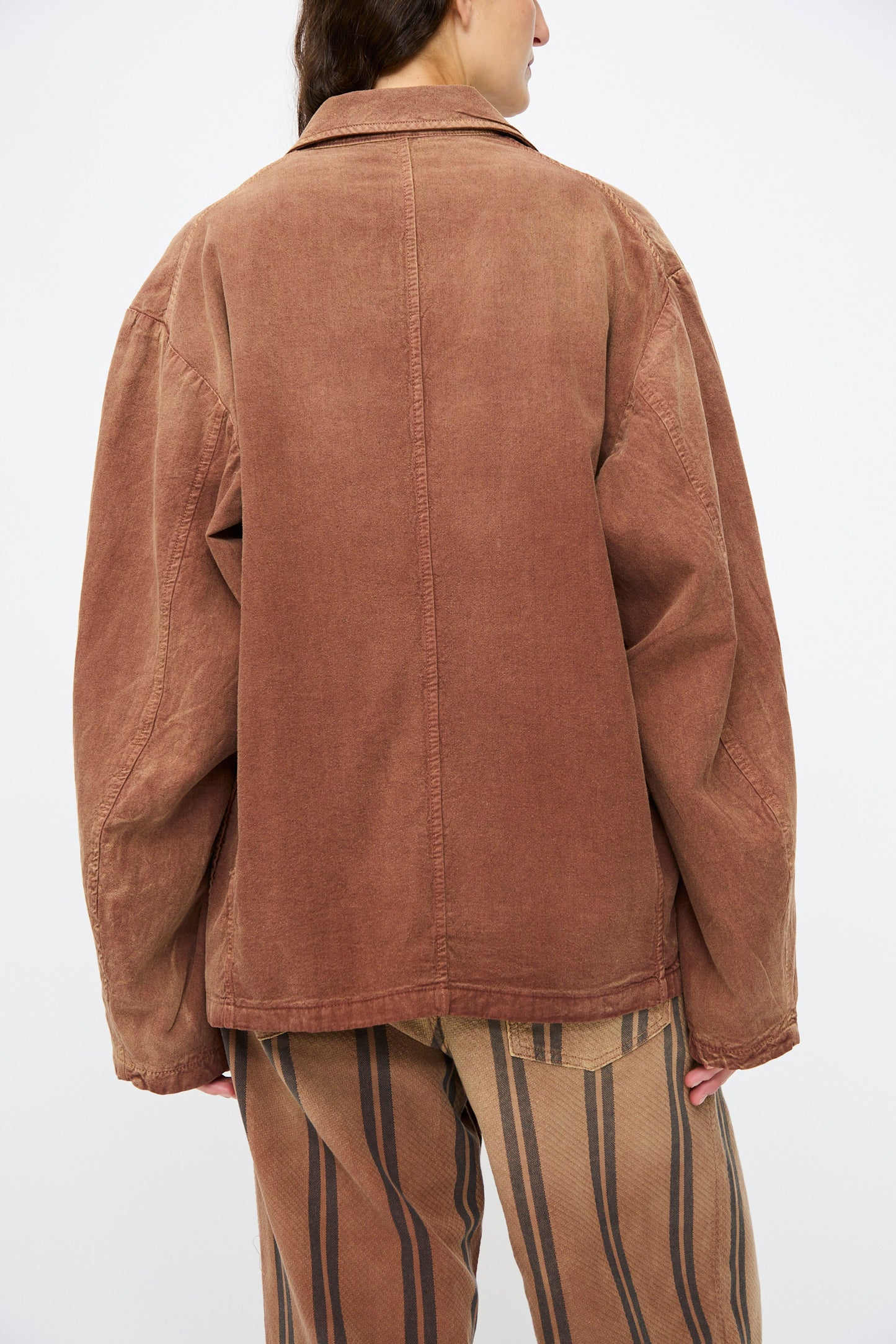 A person wears the Dr. Collectors Bogart Jacket in Nuts, styled with striped pants, seen from behind against a plain light background.