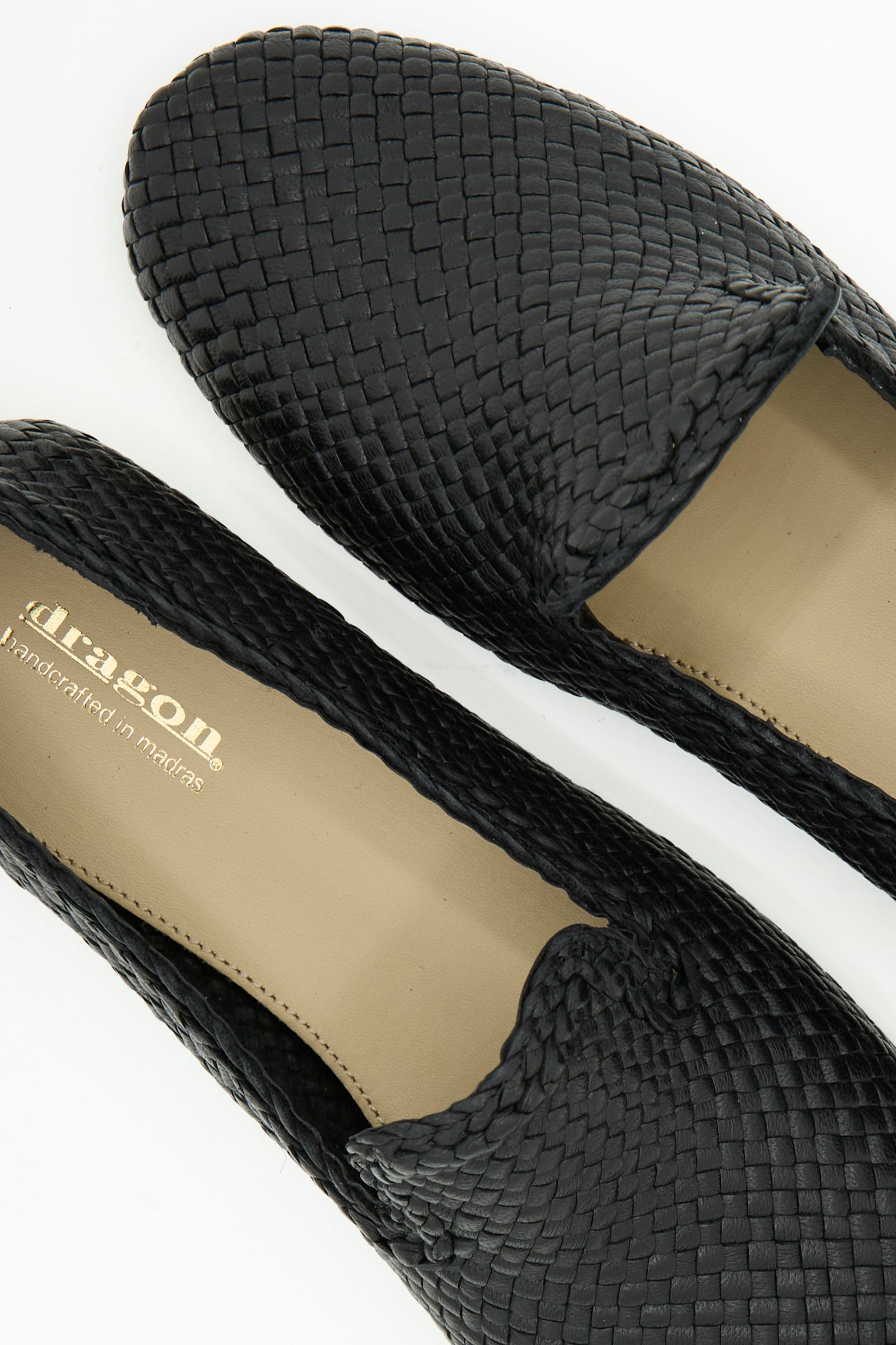 Close-up of the Damas Slipper in Black by Dragon Diffusion, featuring handwoven black leather and tan insoles with the brand name printed inside.