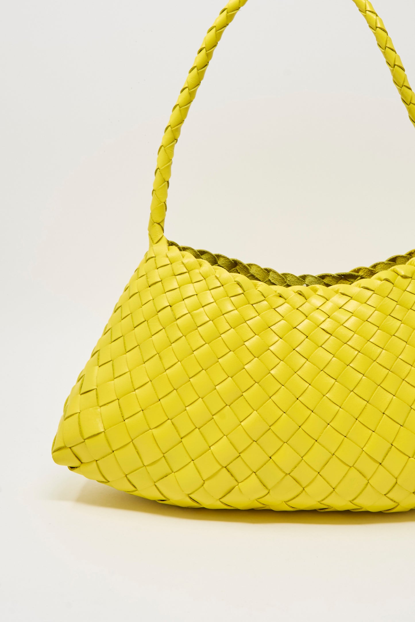 The Rosanna Bag in Yellow by Dragon Diffusion, a handwoven calf leather bag featuring a single braided handle and basket weaving techniques, is showcased against a plain light background.
