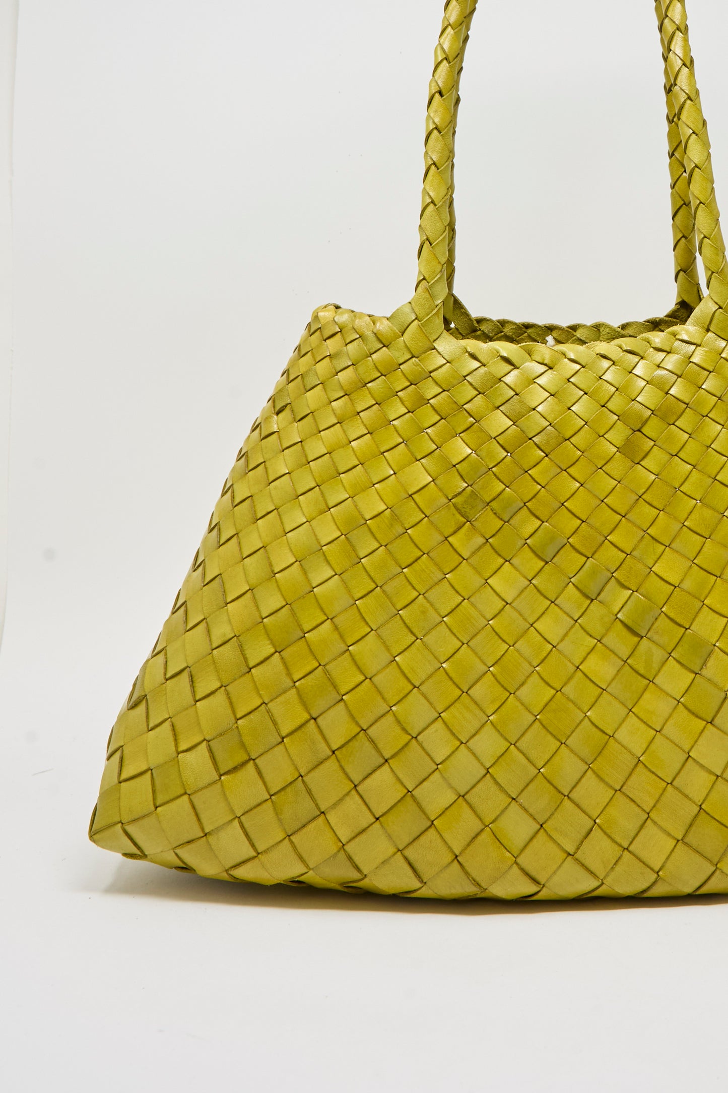 The Santa Croce Big in Bamboo Green by Dragon Diffusion is a handwoven leather bag with two handles, crafted using basket weaving techniques, and shown against a plain white background.