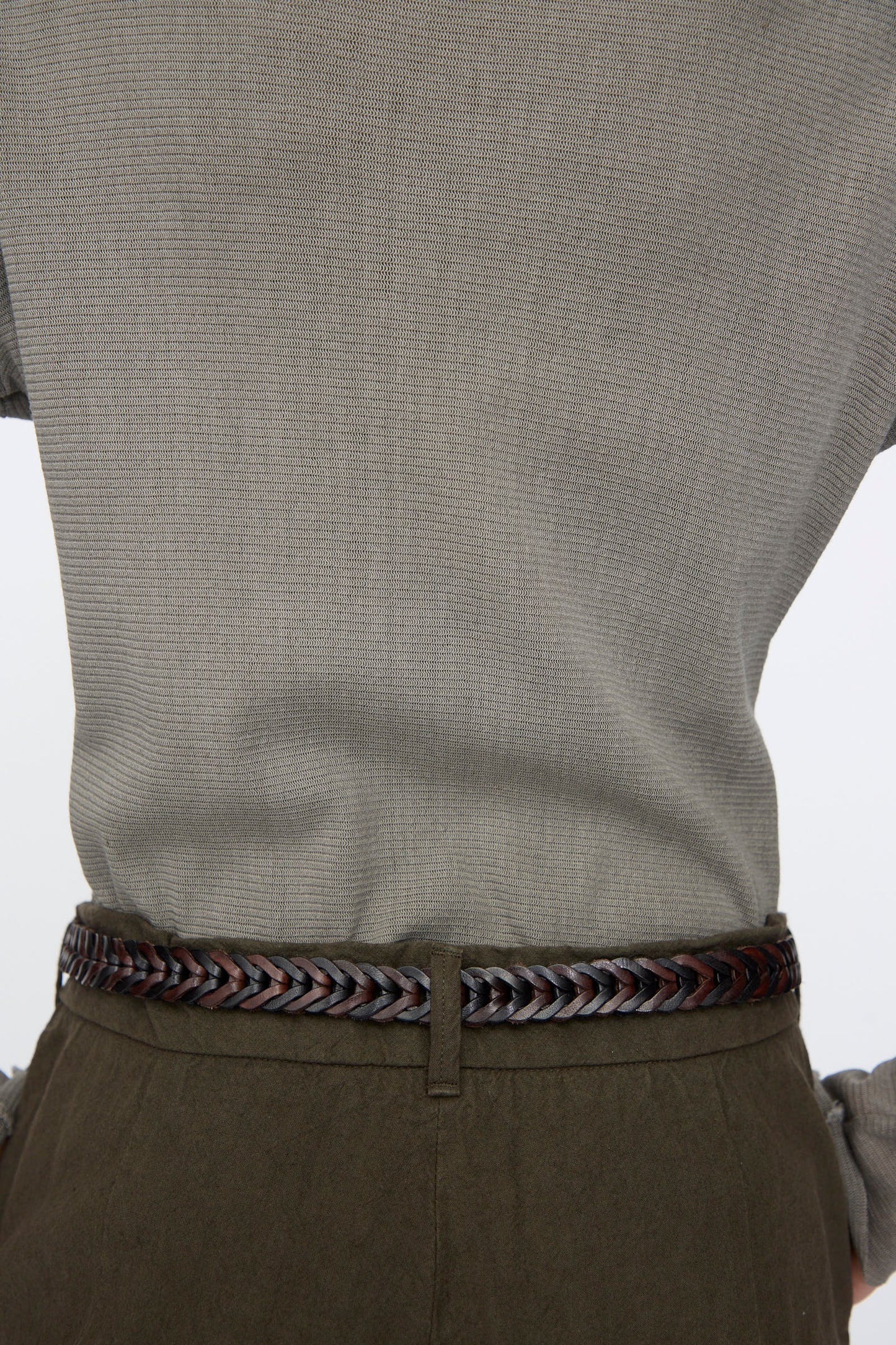 Person wearing a light grey textured shirt tucked into dark olive pants, accessorized with the Dragon Diffusion Single Link Bi-Color Belt in Dark Brown and Black, shown from the back.