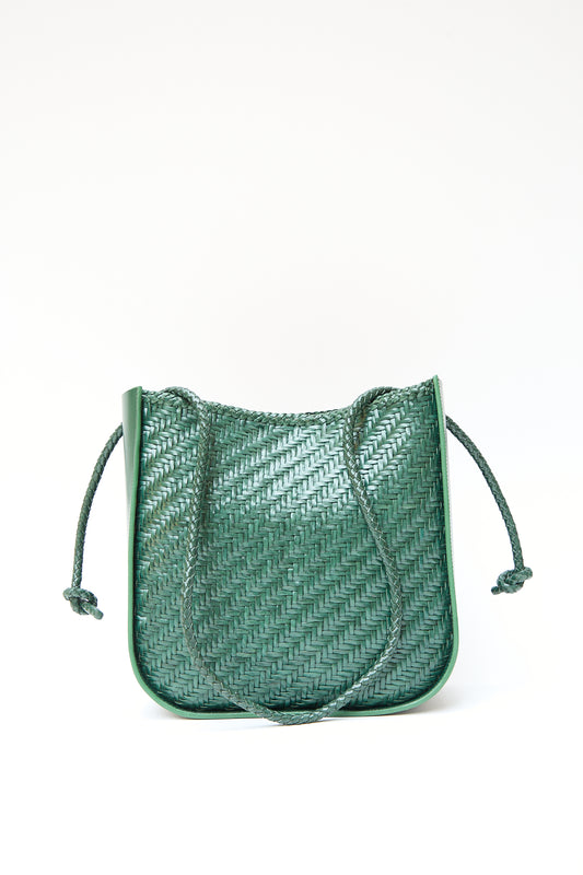 Handwoven Wanaka in Forest buffalo leather shoulder bag with a tasseled drawstring closure on a white background by Dragon Diffusion.