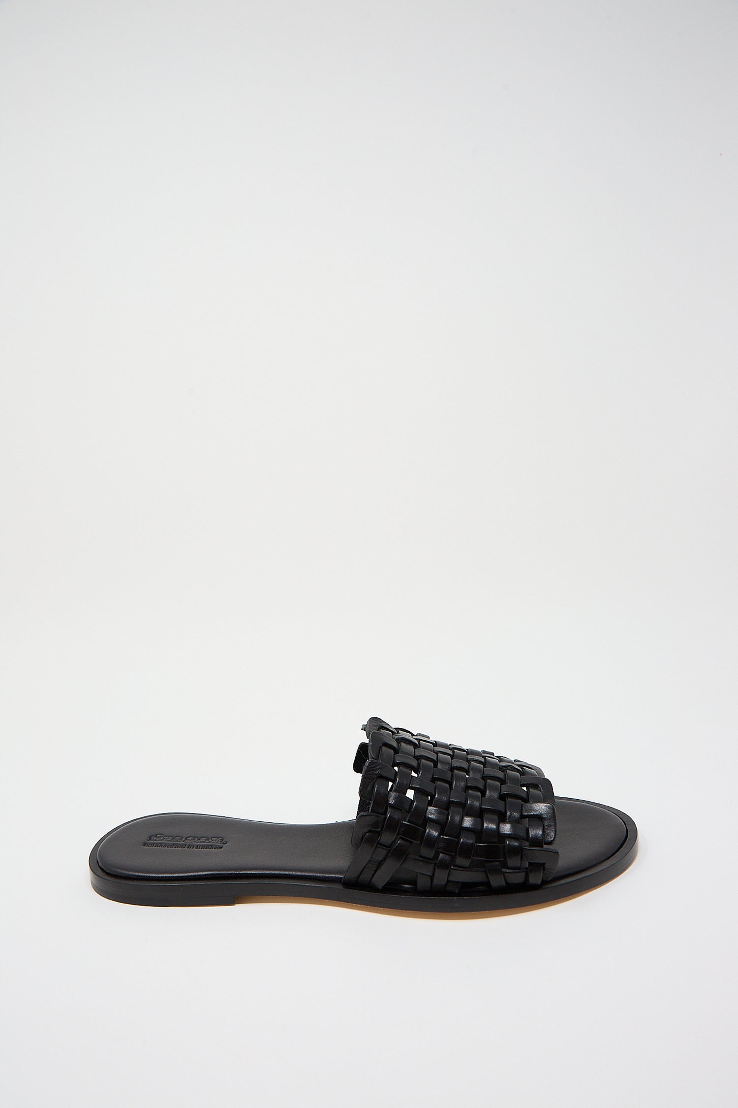 Zig Zag Sandal in Black by Dragon Diffusion, handwoven leather slide sandal on a white background.