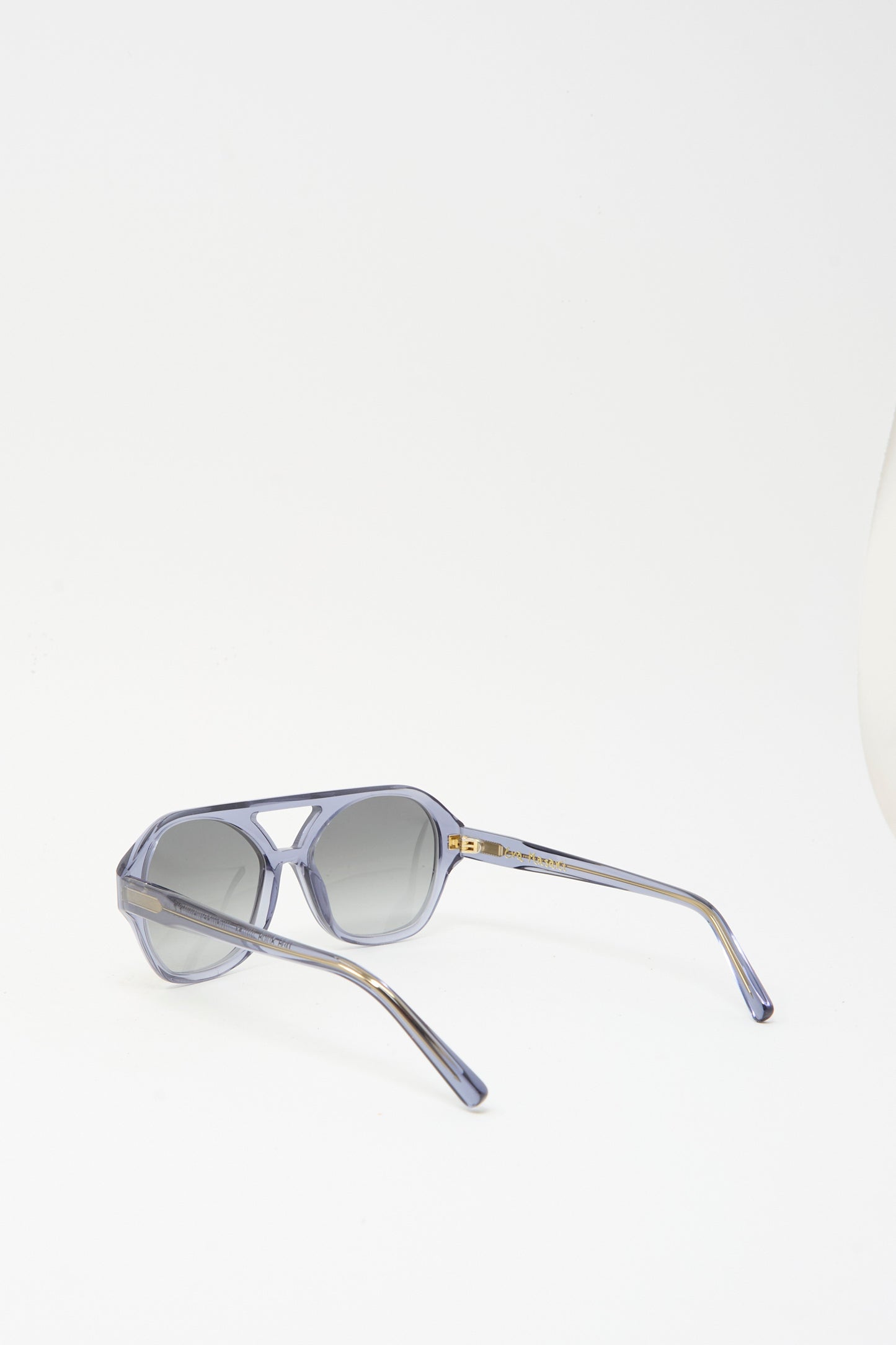 The Chiyo Aviator Sunglasses in Waves by Eva Masaki feature gray lenses and translucent purple Italian acetate frames, blending style with UV protection. Shown on a white background.