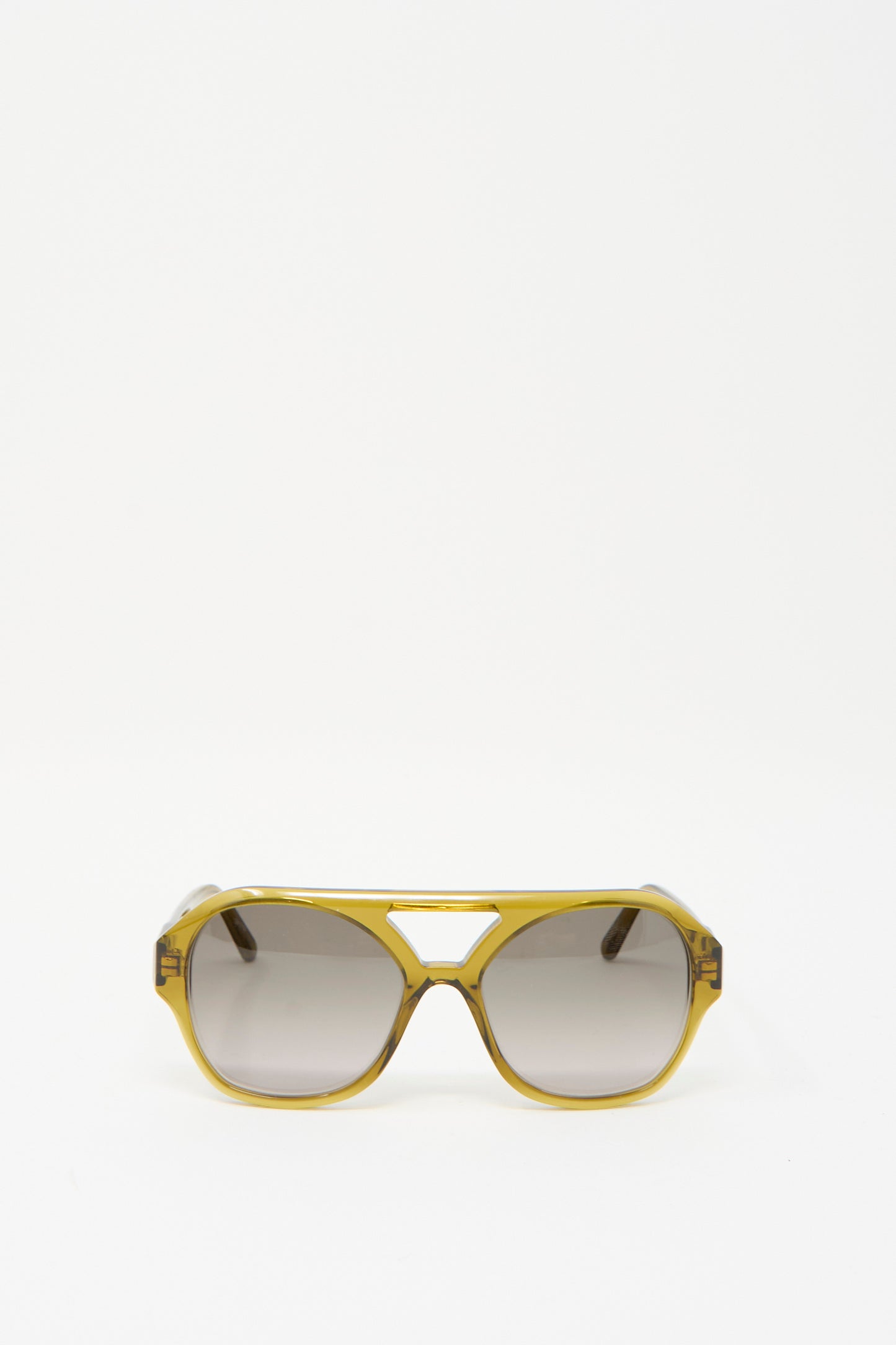 The Chiyo Aviator Sunglasses by Eva Masaki, featuring avocado-colored frames and dark lenses made from Italian acetate, are showcased against a plain white background.