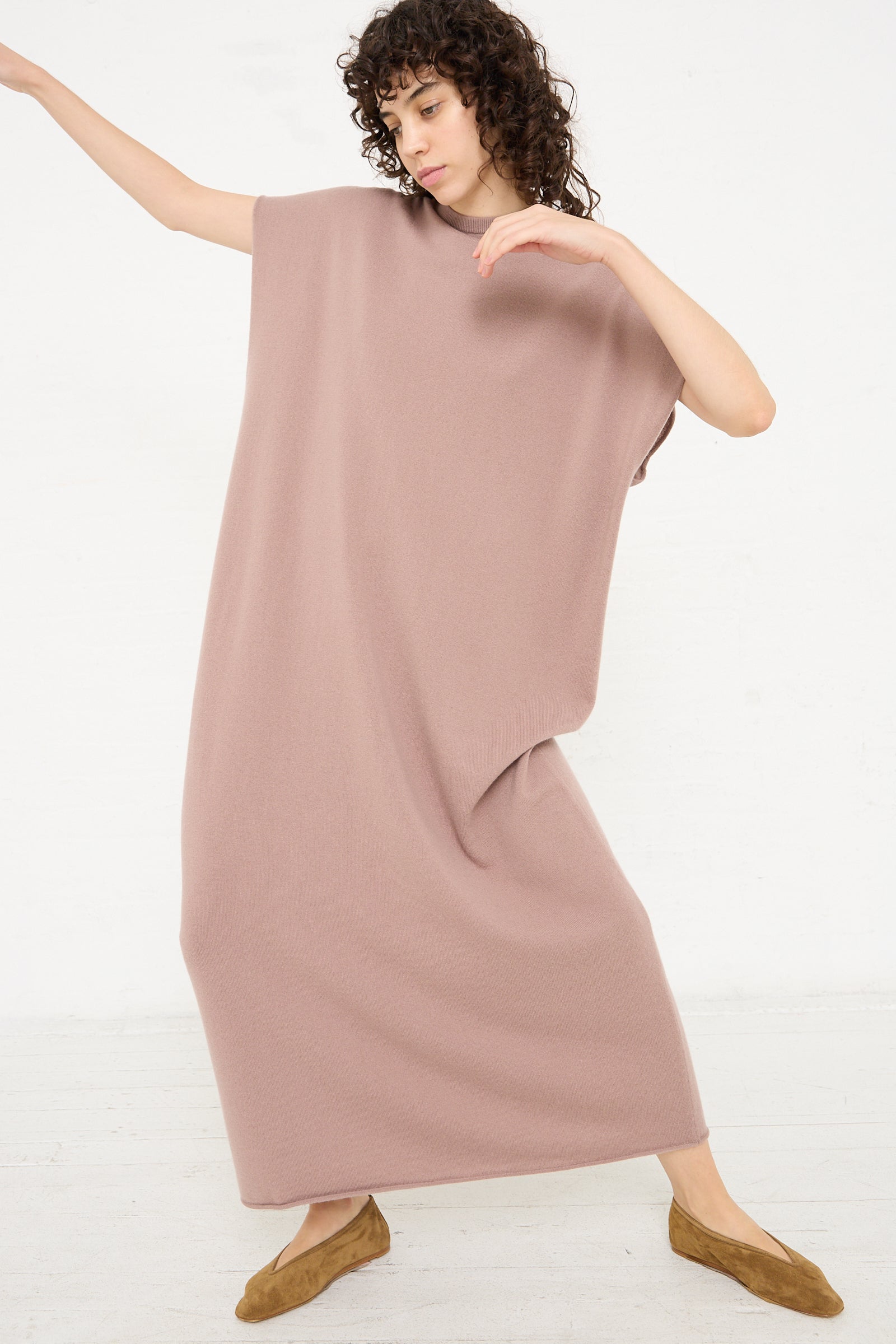 The model is wearing an Extreme Cashmere No. 169 Healing Dress in Clay with long sleeves.