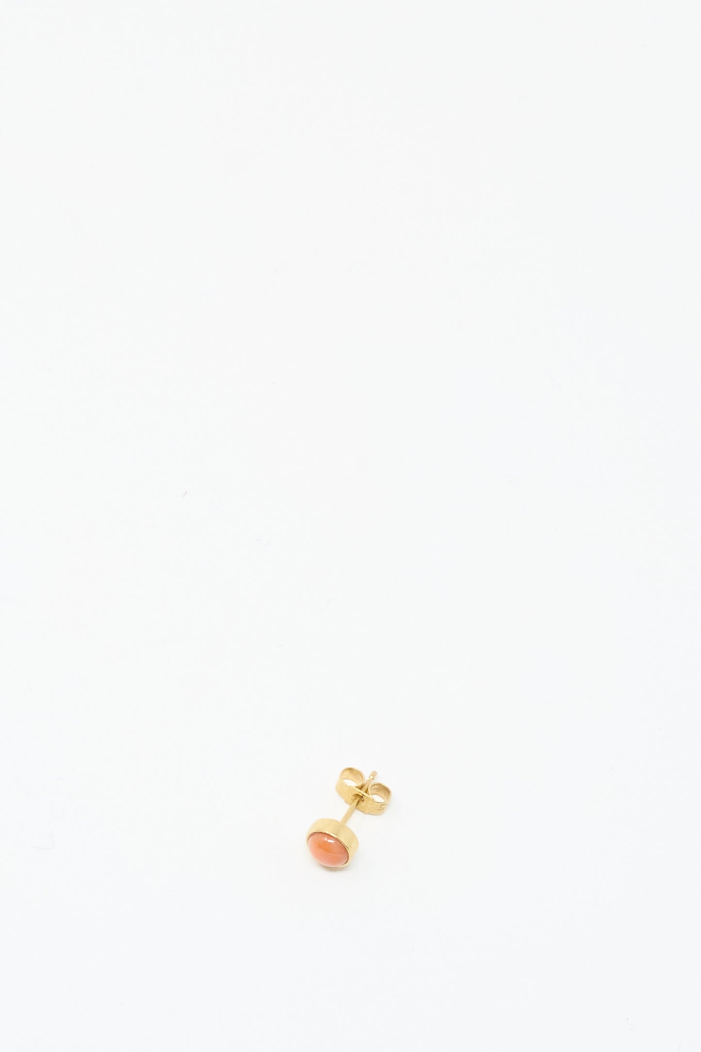 The Stud Earring in Coral by Grainne Morton is a single 18K gold plated stud with a small orange gemstone, handmade in Edinburgh and shown on a plain white background.