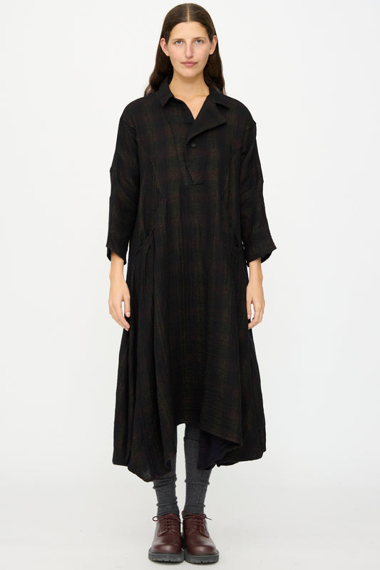 A person wears the Hallelujah Wool Cotton Robe de Berger in Black Mix, styled with gray socks and brown lace-up shoes, standing against a plain white background.
