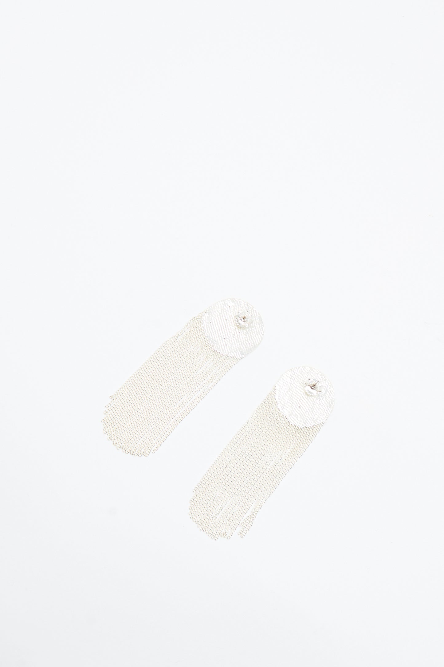 The Dot Earrings in Silver by Hannah Keefe are long, handmade silver earrings with circular tops and cascading chain fringes, shown on a white background.