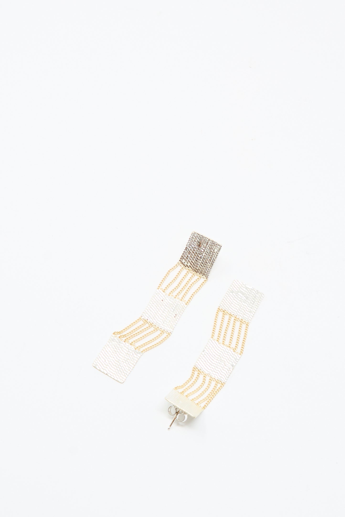 Add a touch of Los Angeles style with Hannah Keefe’s Train Earrings in Brass and Silver—handmade, long rectangular earrings featuring a geometric textured design.