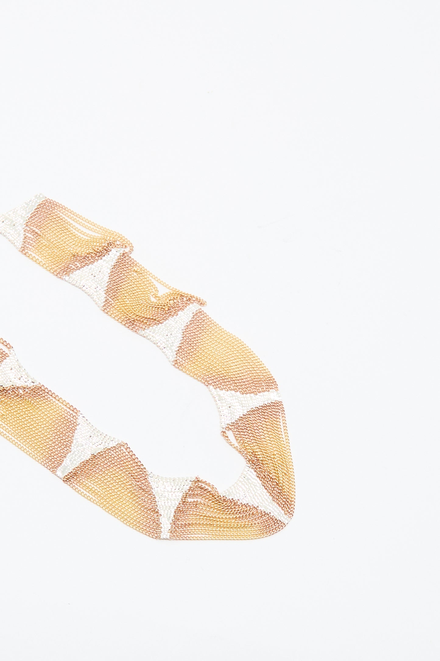 The Deanna Necklace in Brass and Silver by Hannah Keefe is displayed on a white background, featuring diamond-shaped patterns reminiscent of a triangle motif.