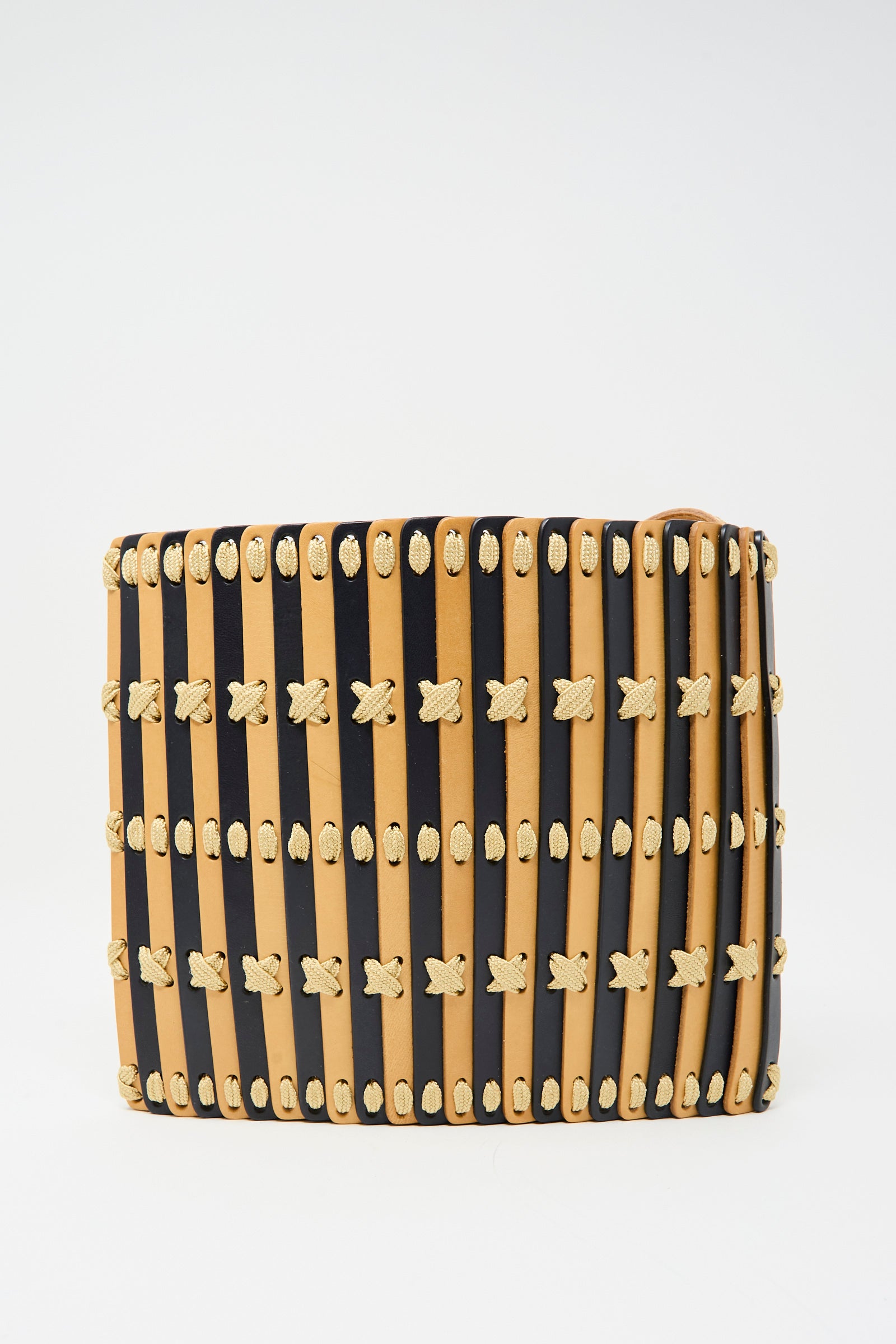 Hatori’s Leather Crossbody 48 features alternating vertical strips of midnight blue leather, ecru lace accents with X-shaped stitching, and an adjustable shoulder strap.