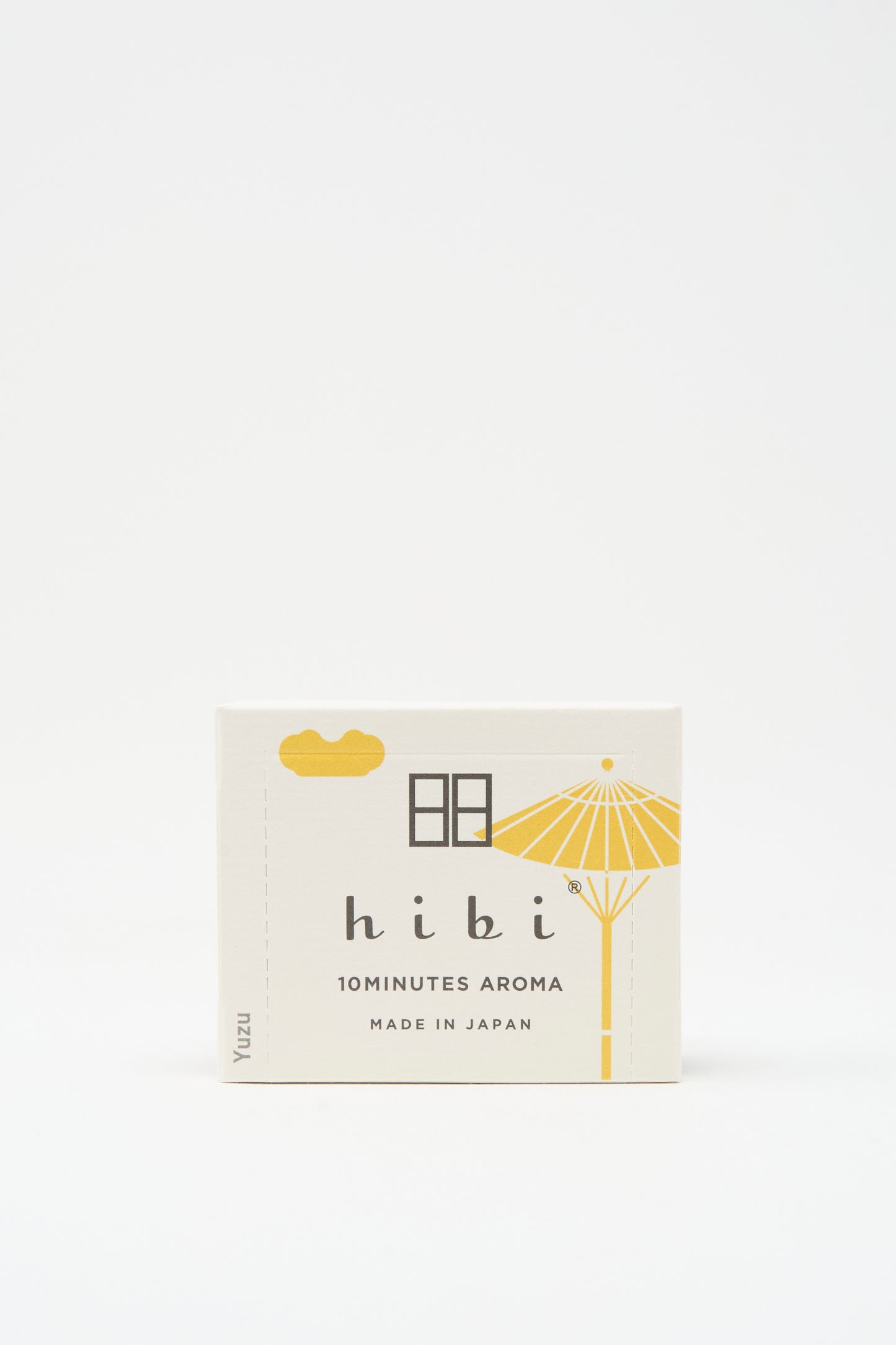 A small box labeled "Hibi Incense Matches" features minimalist yellow parasol and cloud illustrations on white, offering handcrafted incense made in Japan for a gentle citrus aroma.