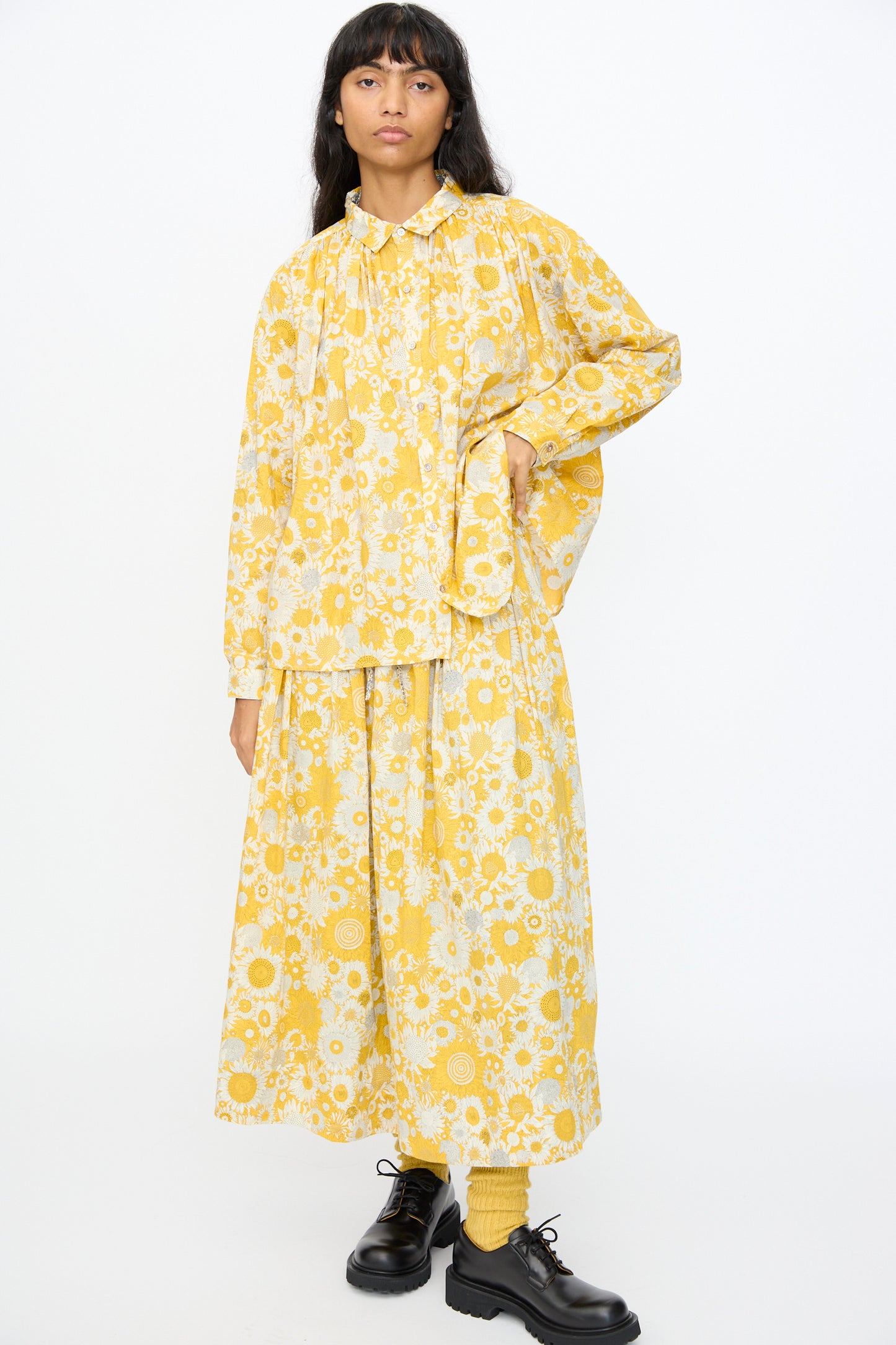 Person standing against a white background wearing the Ichi Antiquités Cotton Liberty Shirt in Yellow and matching skirt, paired with yellow socks and black shoes.
