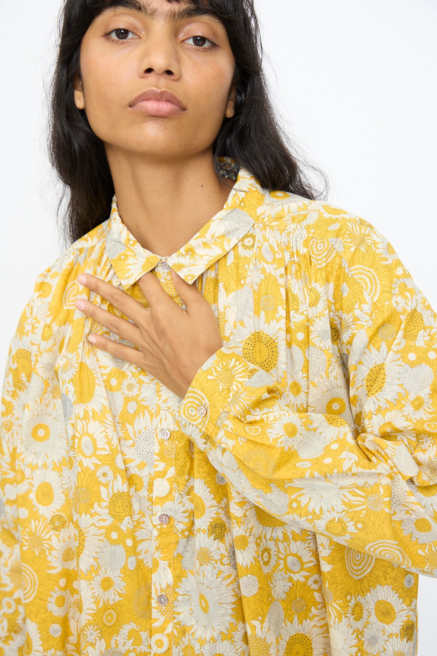 A person with long dark hair wears the Ichi Antiquités Cotton Liberty Shirt in Yellow, standing against a plain white background with one hand on their chest.