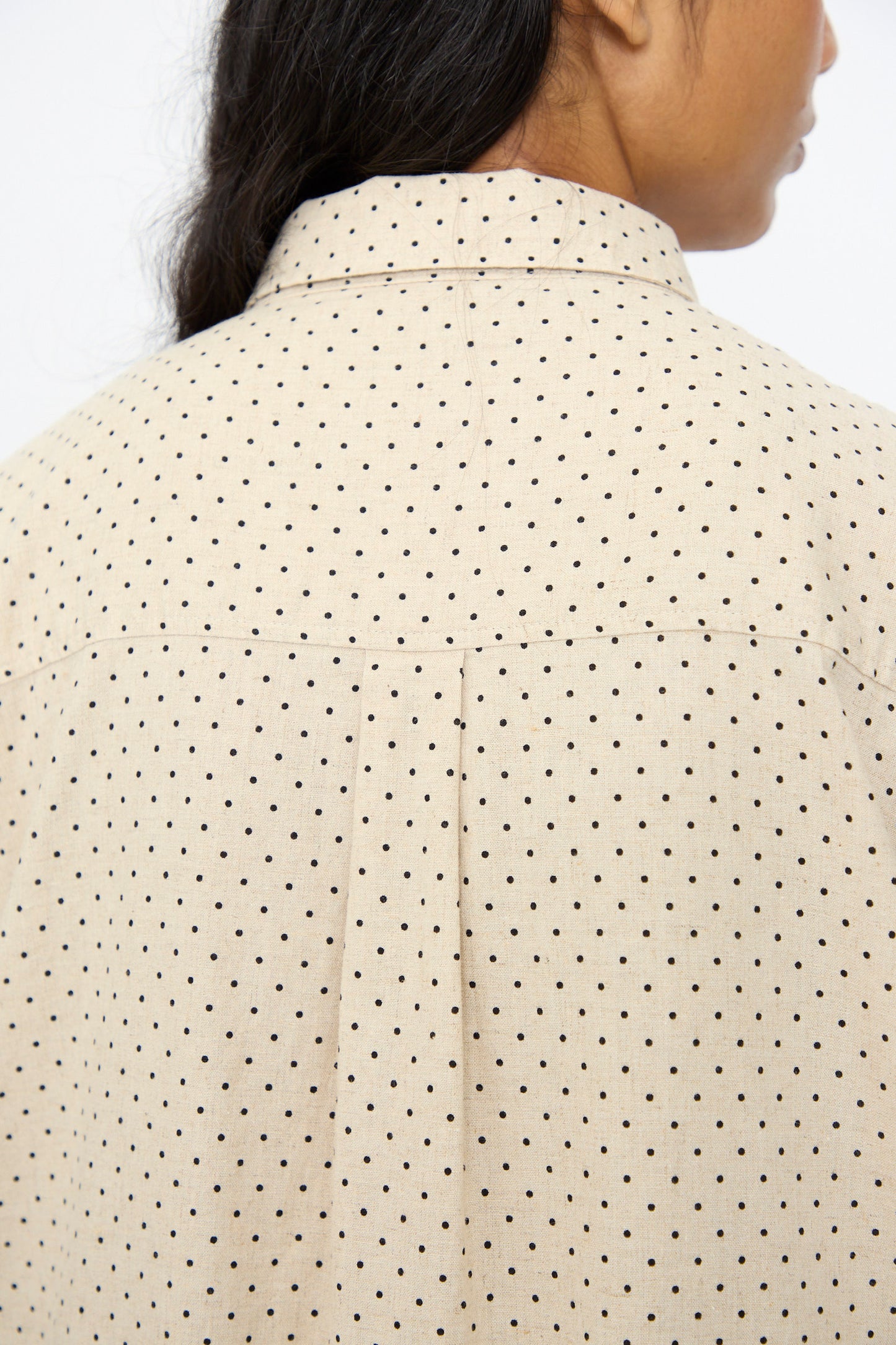 Close-up of a person wearing the Ichi Antiquités Cotton Linen Dot Dress in Natural, showcasing the collar and upper back details with black polka dots.