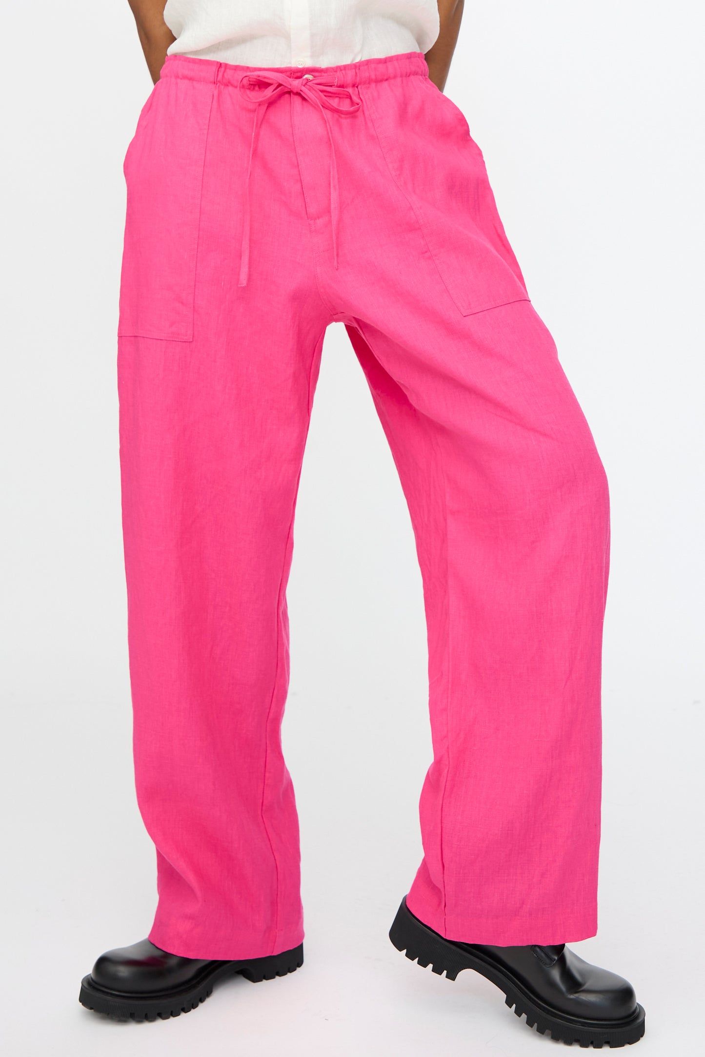 A person wears Ichi Antiquités Color Linen Pants in Pink—relaxed fit, made in Japan—with black chunky shoes, standing against a plain white background.