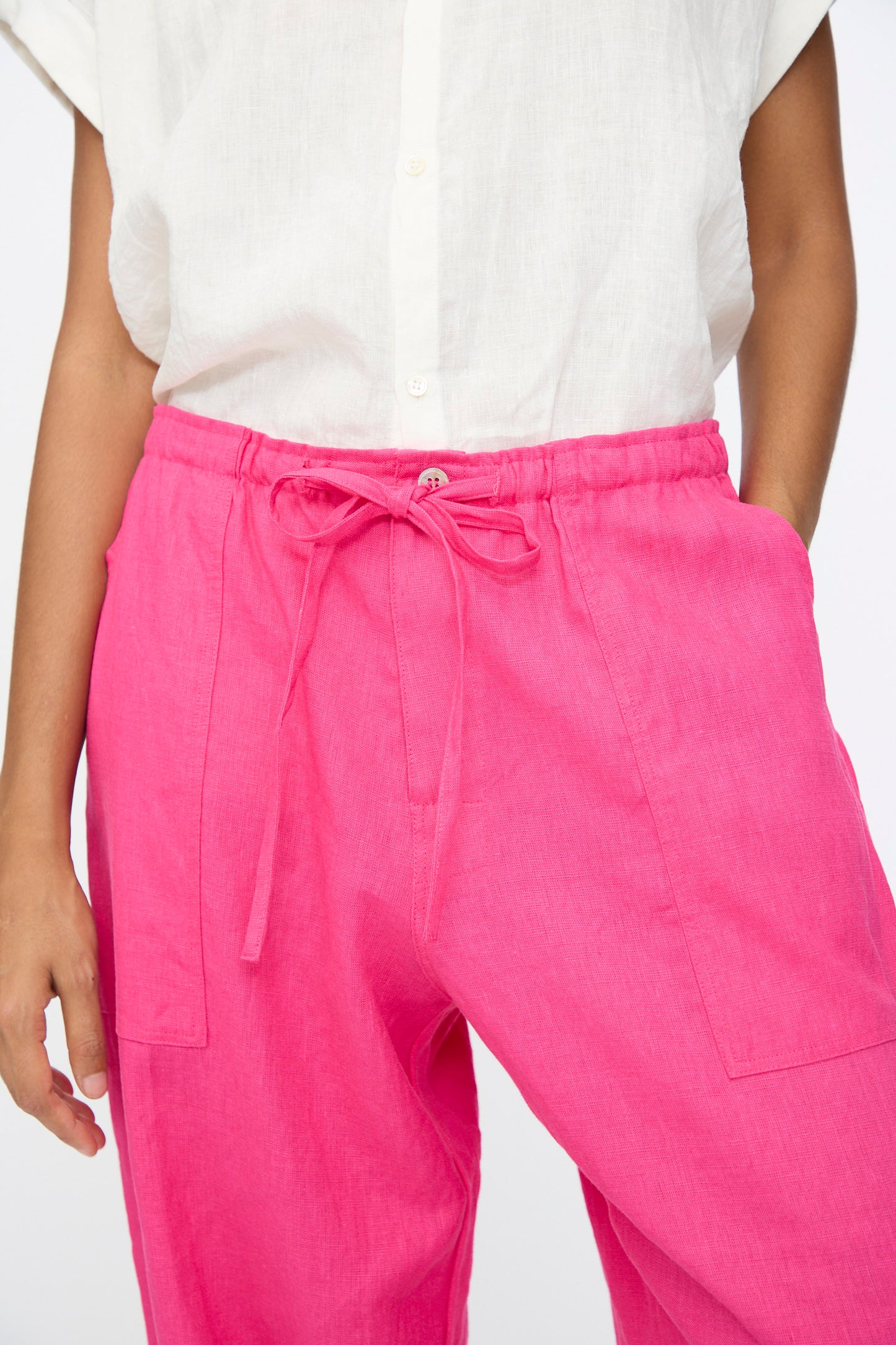 Model in Ichi Antiquités Color Linen Pants in Pink, styled with a white short-sleeve button-up shirt; shown from shoulders to mid-thigh.
