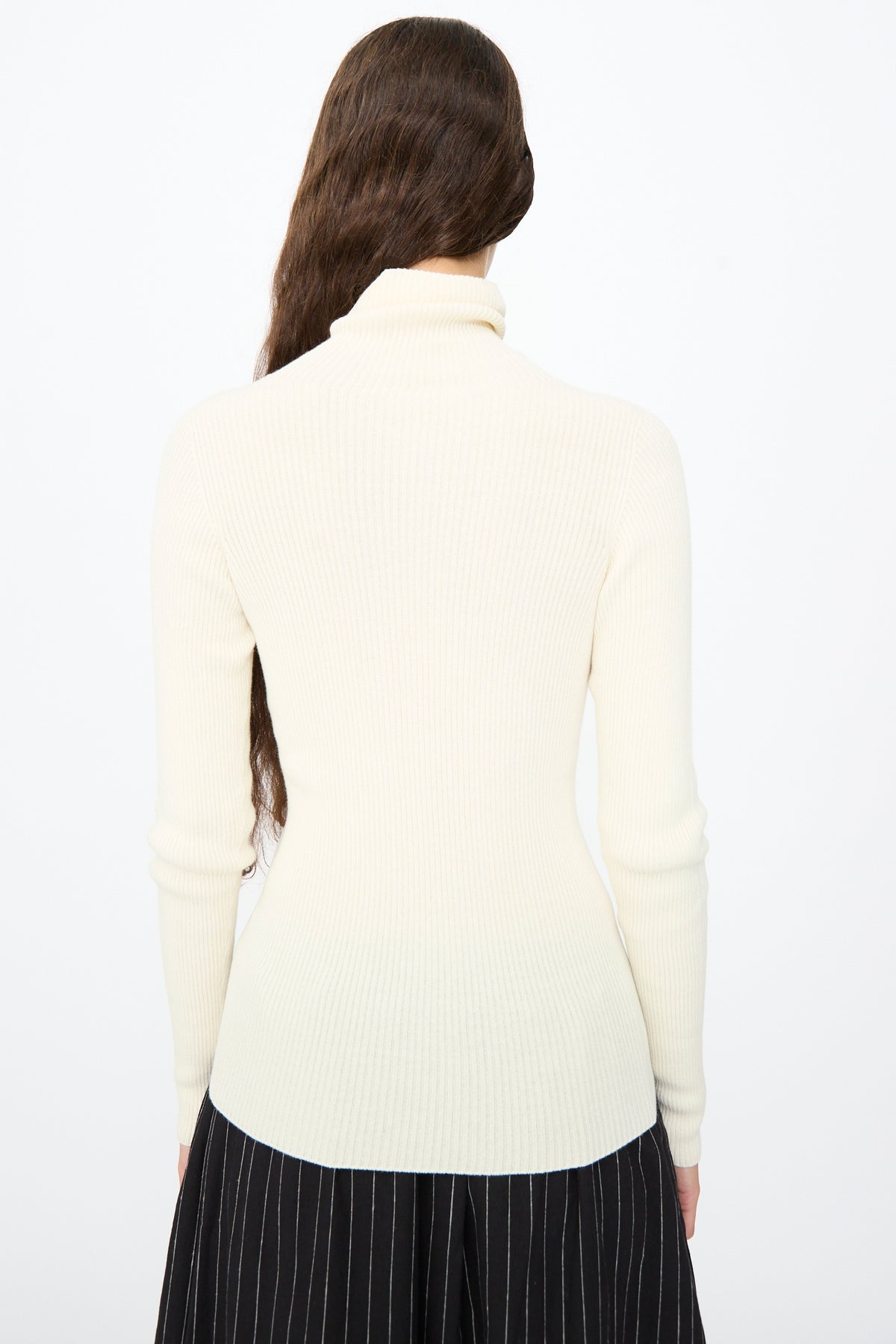 Back view of an Ichi Antiquités Cotton Rib Turtleneck in Ivory worn over a black pinstriped skirt.