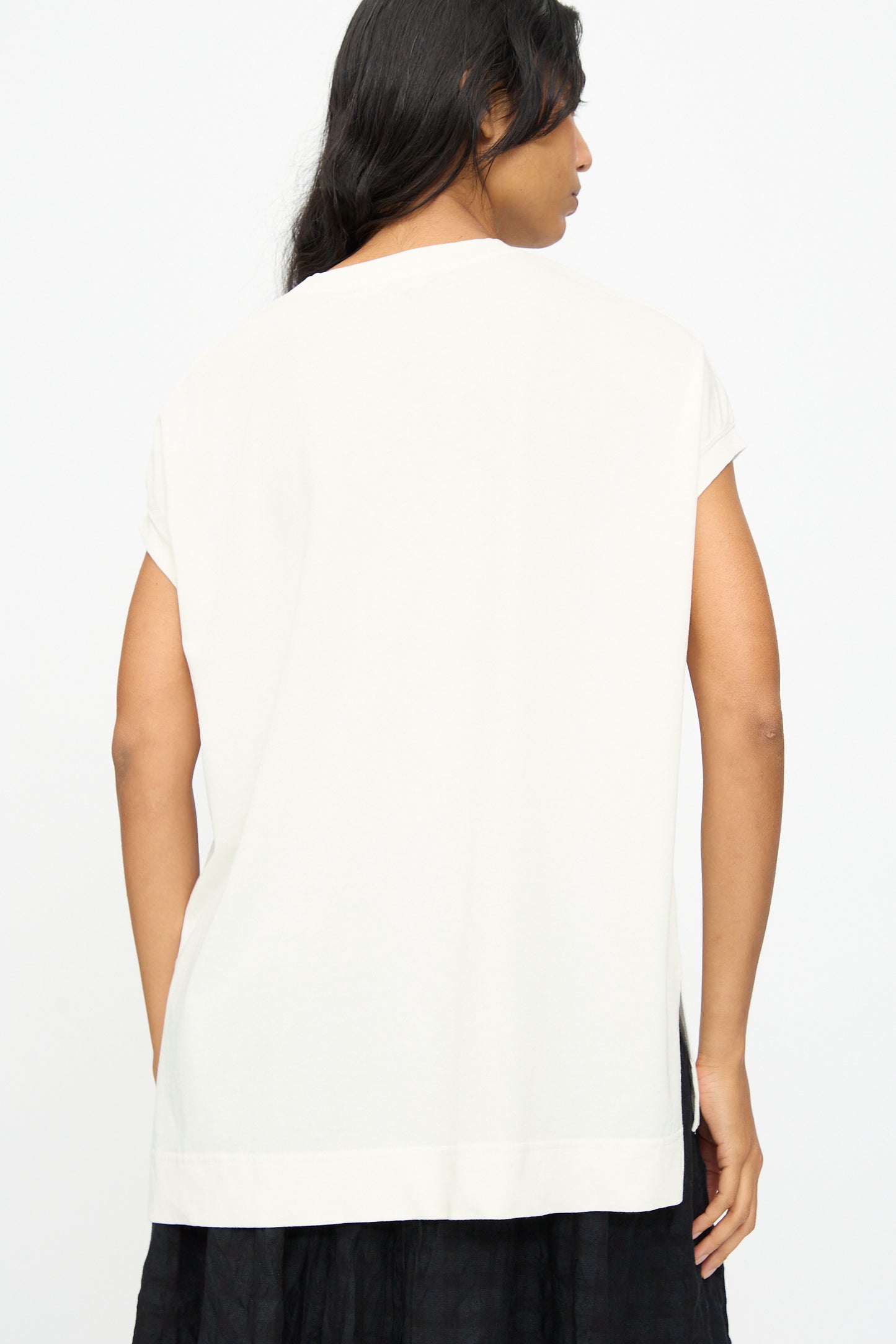 A person with long dark hair is shown from the back wearing the Ichi Antiquités Cotton Sleeveless Tee in White and a black skirt, against a plain white background.