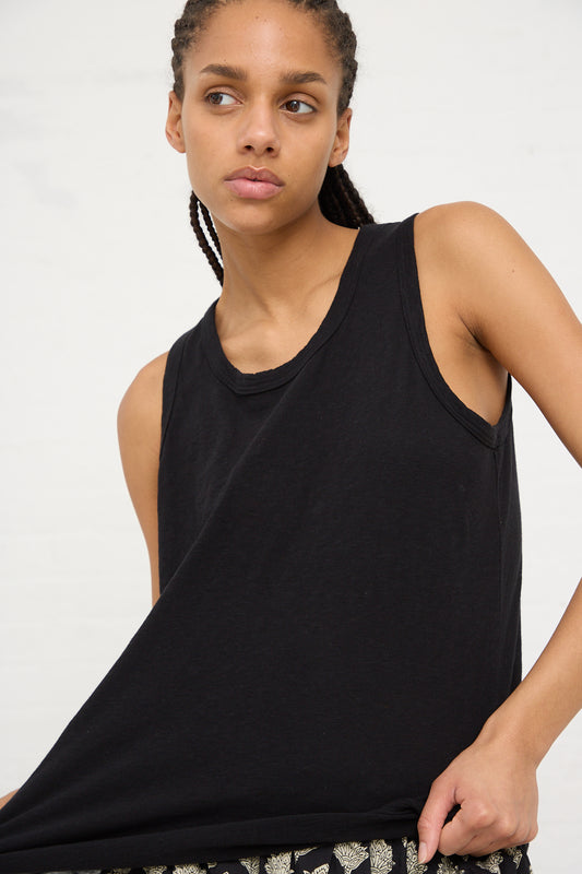 A woman in a black Cotton Tank by Ichi Antiquités looking to the side.
