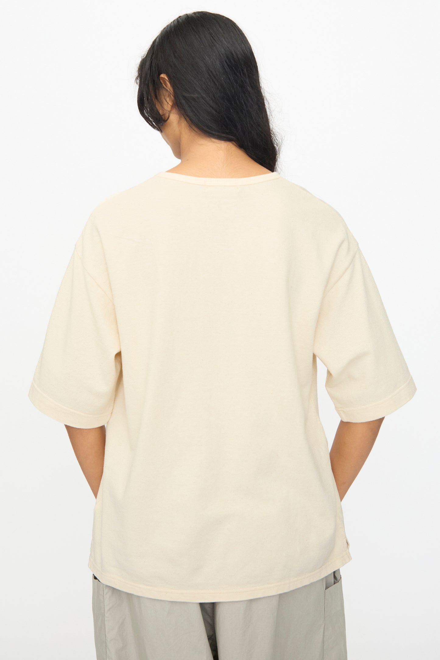 A person with long dark hair wears the Ichi Antiquités Cotton Thermal Henley Neck Pullover in Ivory, shown from the back against a plain white background.