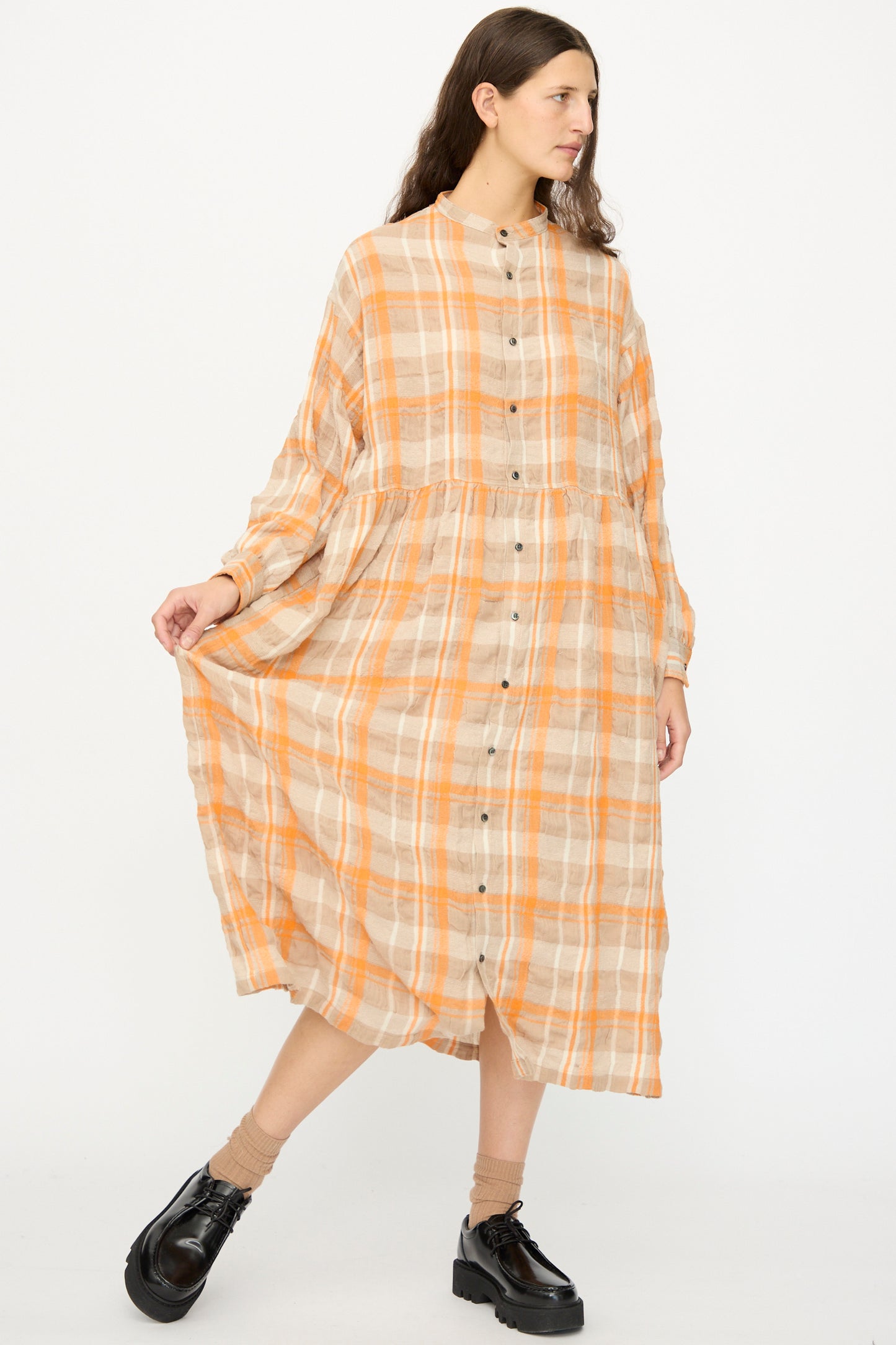 A woman in the Ichi Antiquités Cotton Wool Tartan Check Dress in Orange stands against a plain white background, wearing black platform shoes.
