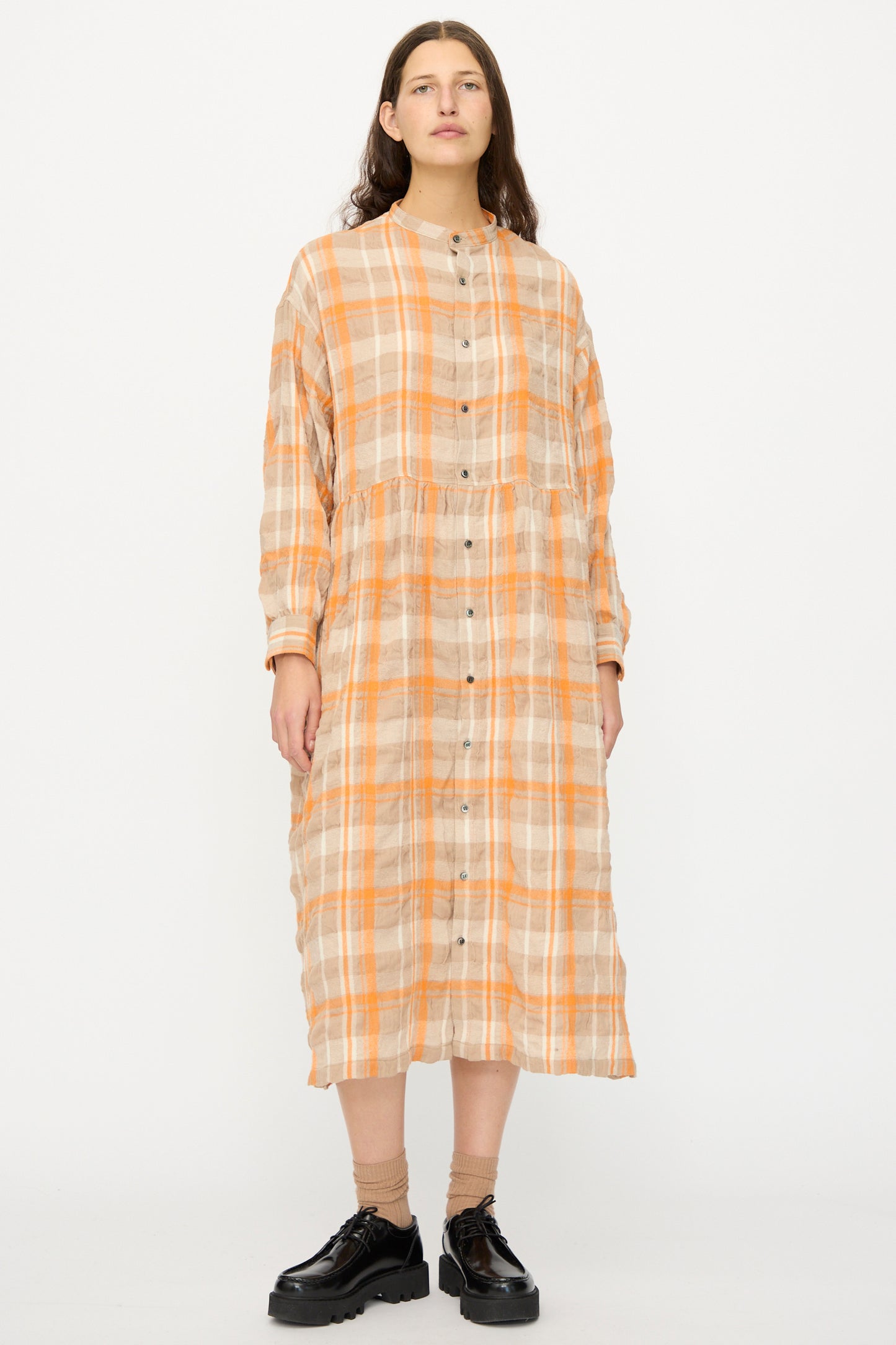 A person stands facing forward in the Ichi Antiquités Cotton Wool Tartan Check Dress in Orange, paired with black shoes, against a white background.