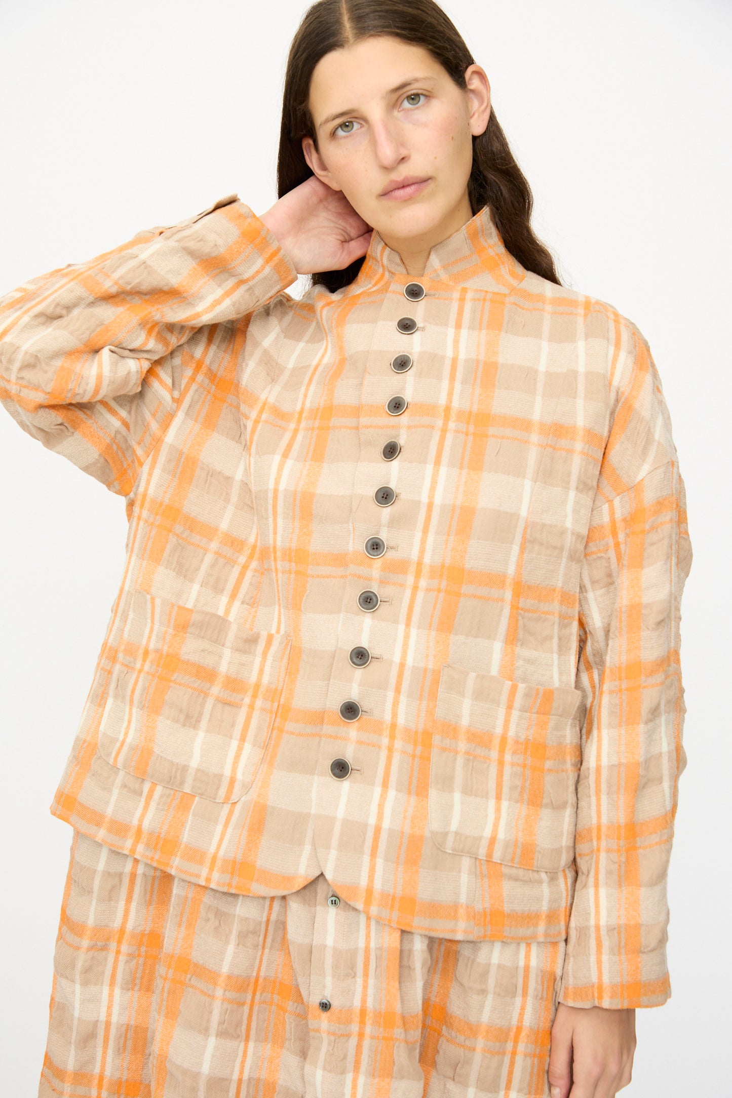 A woman wears the Ichi Antiquités Cotton Wool Tartan Check Jacket in Orange, featuring large front pockets, paired with a matching skirt—both made in Japan—against a plain white background.