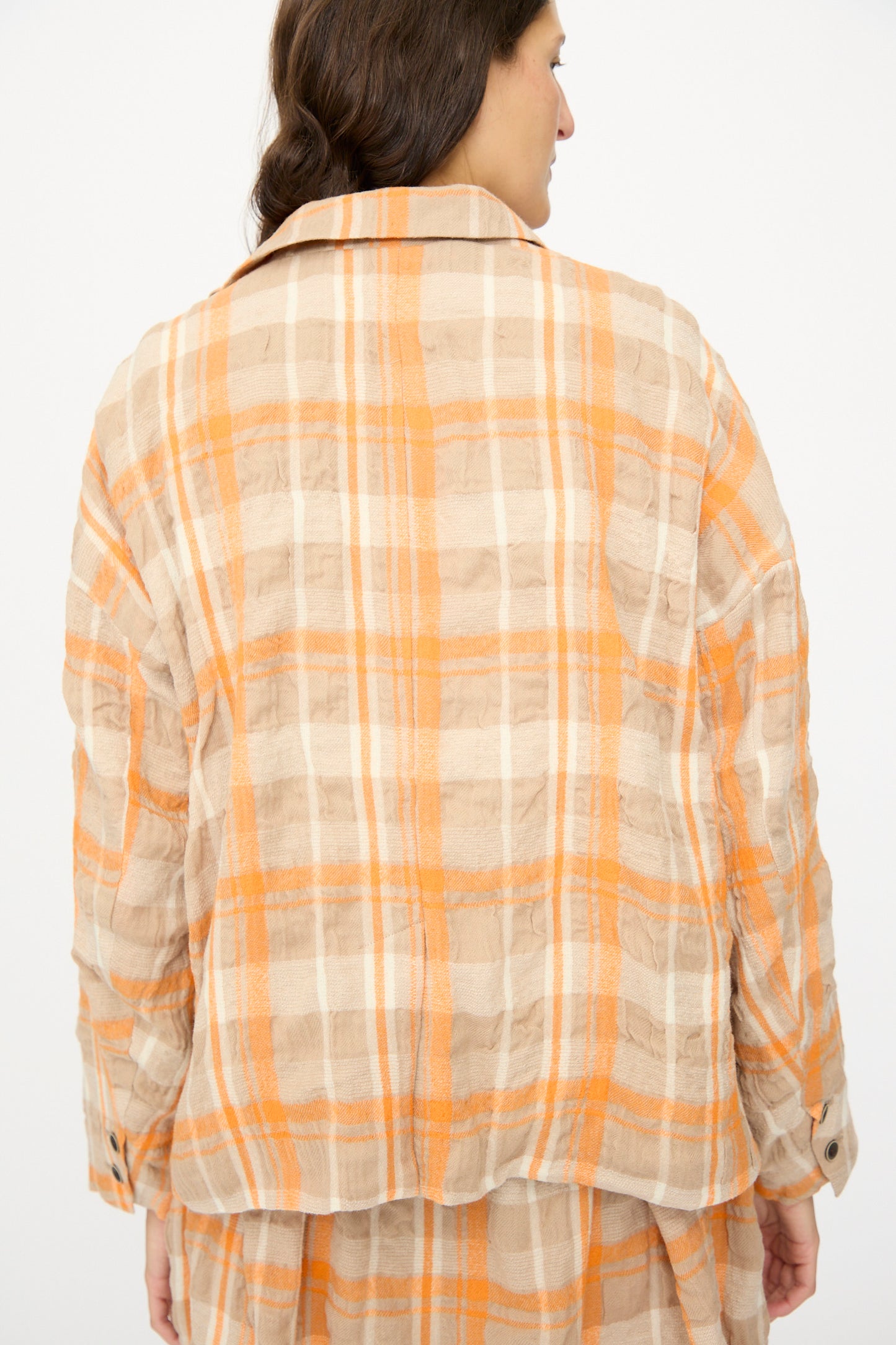 A person wearing the Ichi Antiquités Cotton Wool Tartan Check Jacket in Orange is shown from the back, head turned slightly to the side against a plain background.