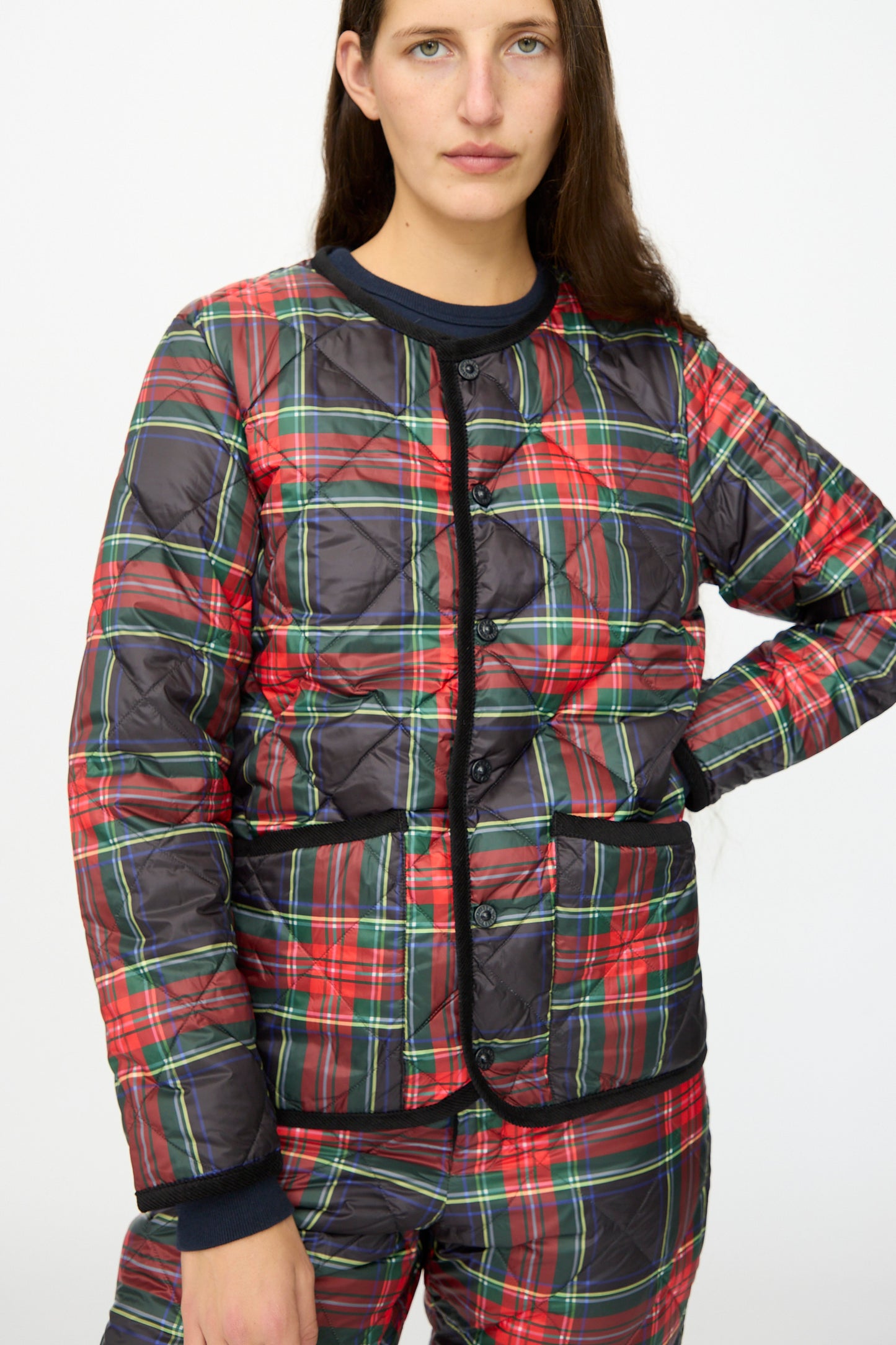 A person wearing the Ichi Antiquités Down Jacket in Black Tartan with black corduroy trim and matching pants, standing against a plain white background.