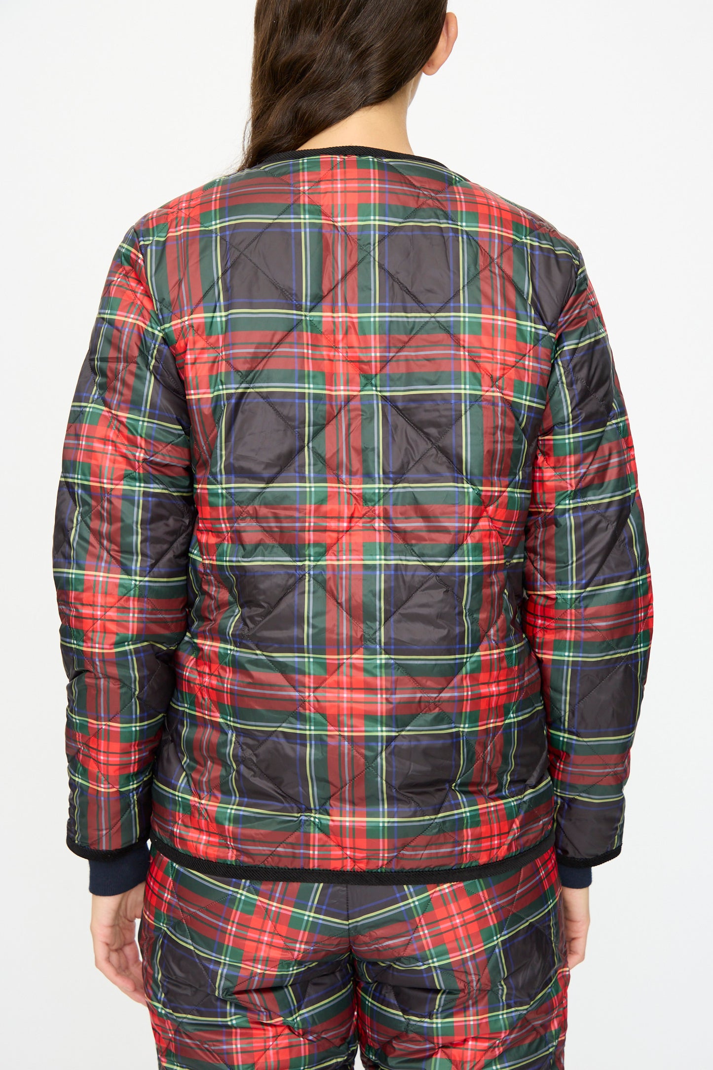 A person is seen from the back wearing the Down Jacket in Black Tartan by Ichi Antiquités, featuring black corduroy trim and matching pants, set against a plain background.