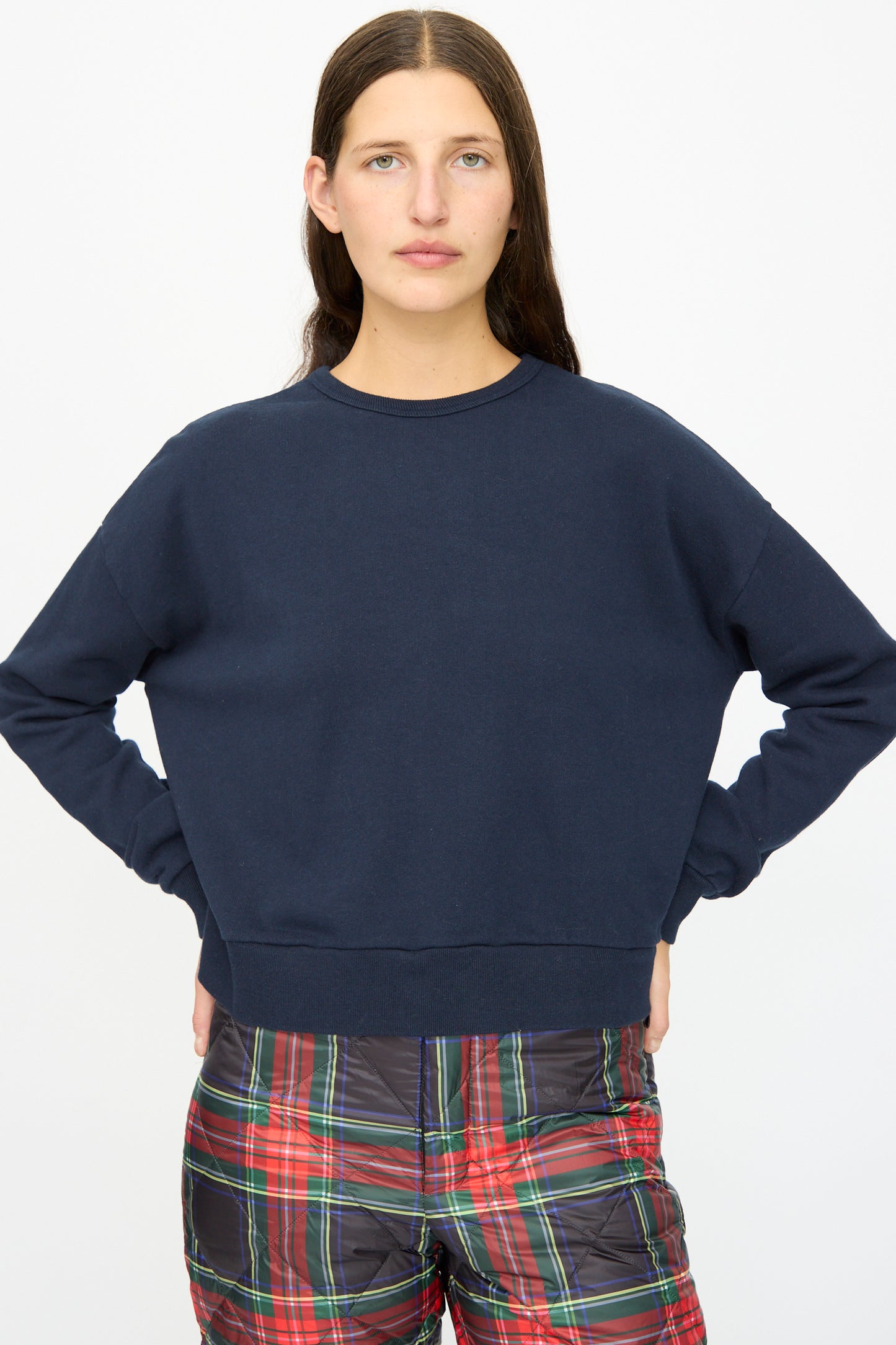 A person stands with hands on hips, wearing the Ichi Antiquités French Terry Cotton Pullover in Navy and red plaid shorts against a plain white background.