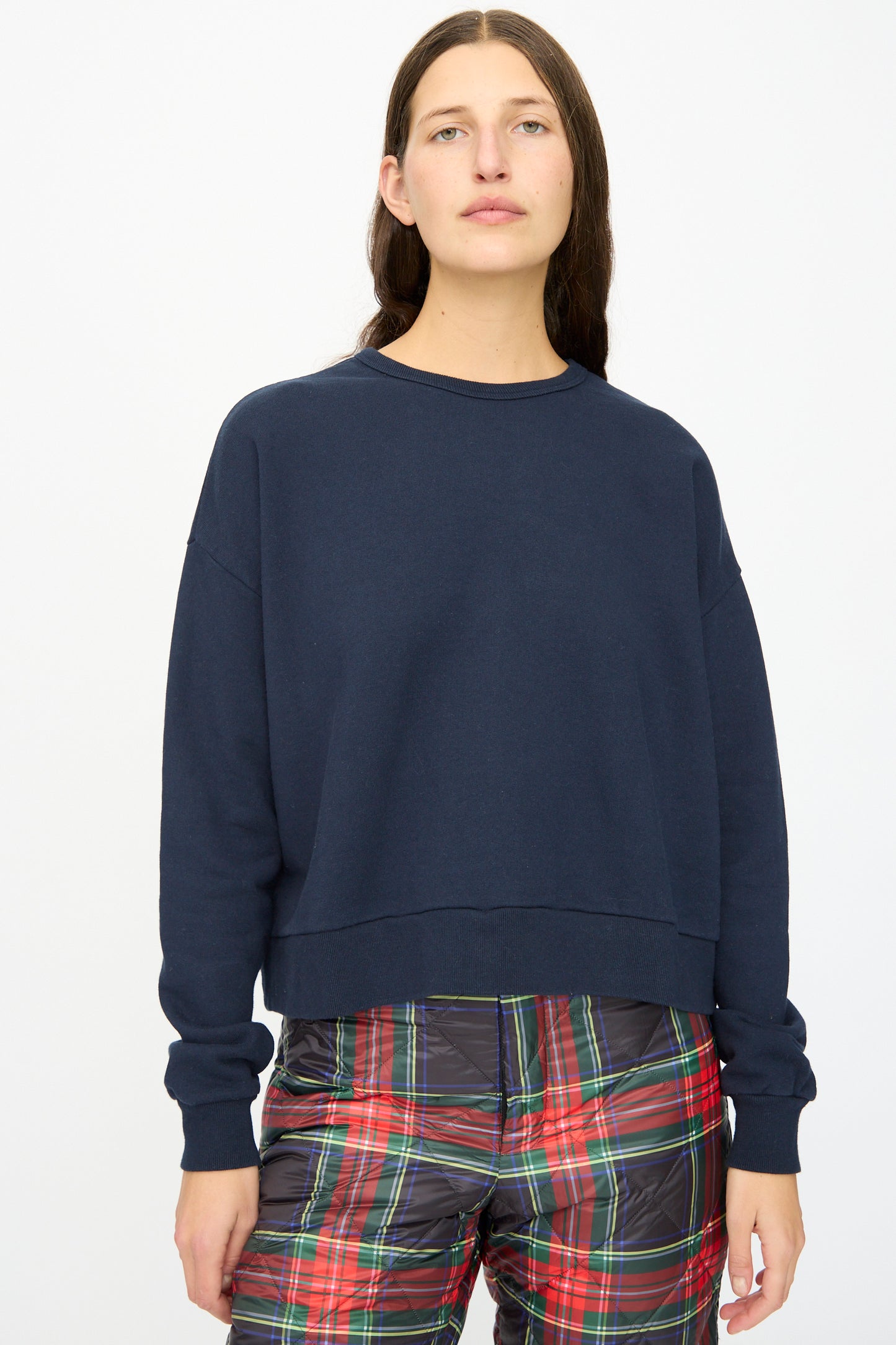 A person wears the Ichi Antiquités French Terry Cotton Pullover in Navy with red-green plaid pants, standing against a plain white background.