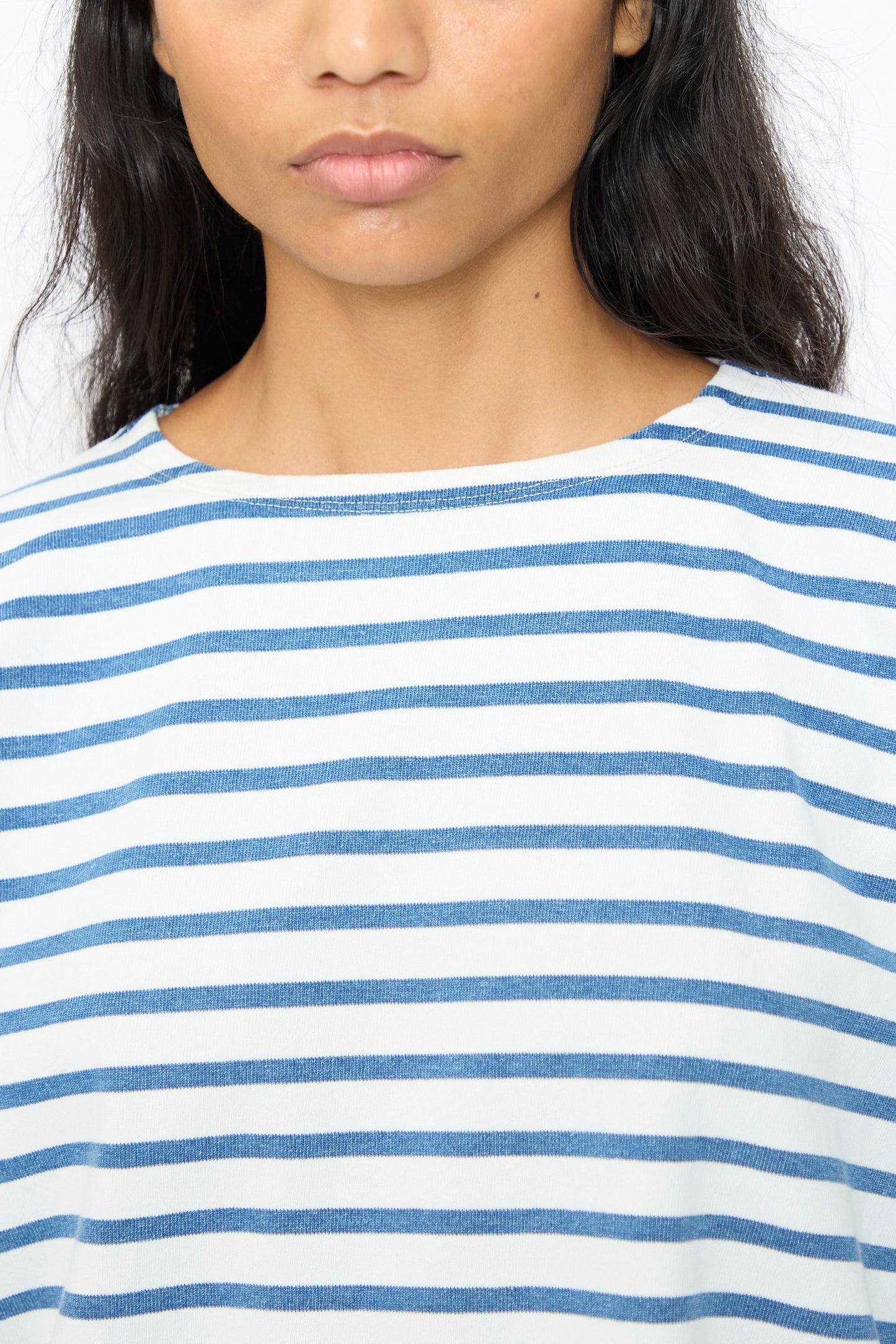 A woman with long dark hair models the Ichi Antiquités Indigo Pullover Tee in White and Blue, shown from the shoulders up against a plain background.