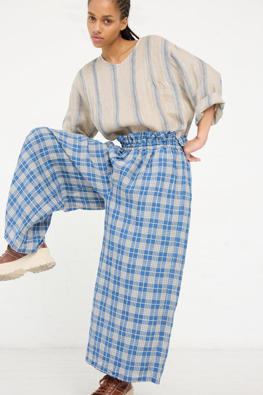 Woman posing in a room wearing a striped top and Ichi Antiquités Linen Check Pant in Light Indigo and Natural wide-leg pants.