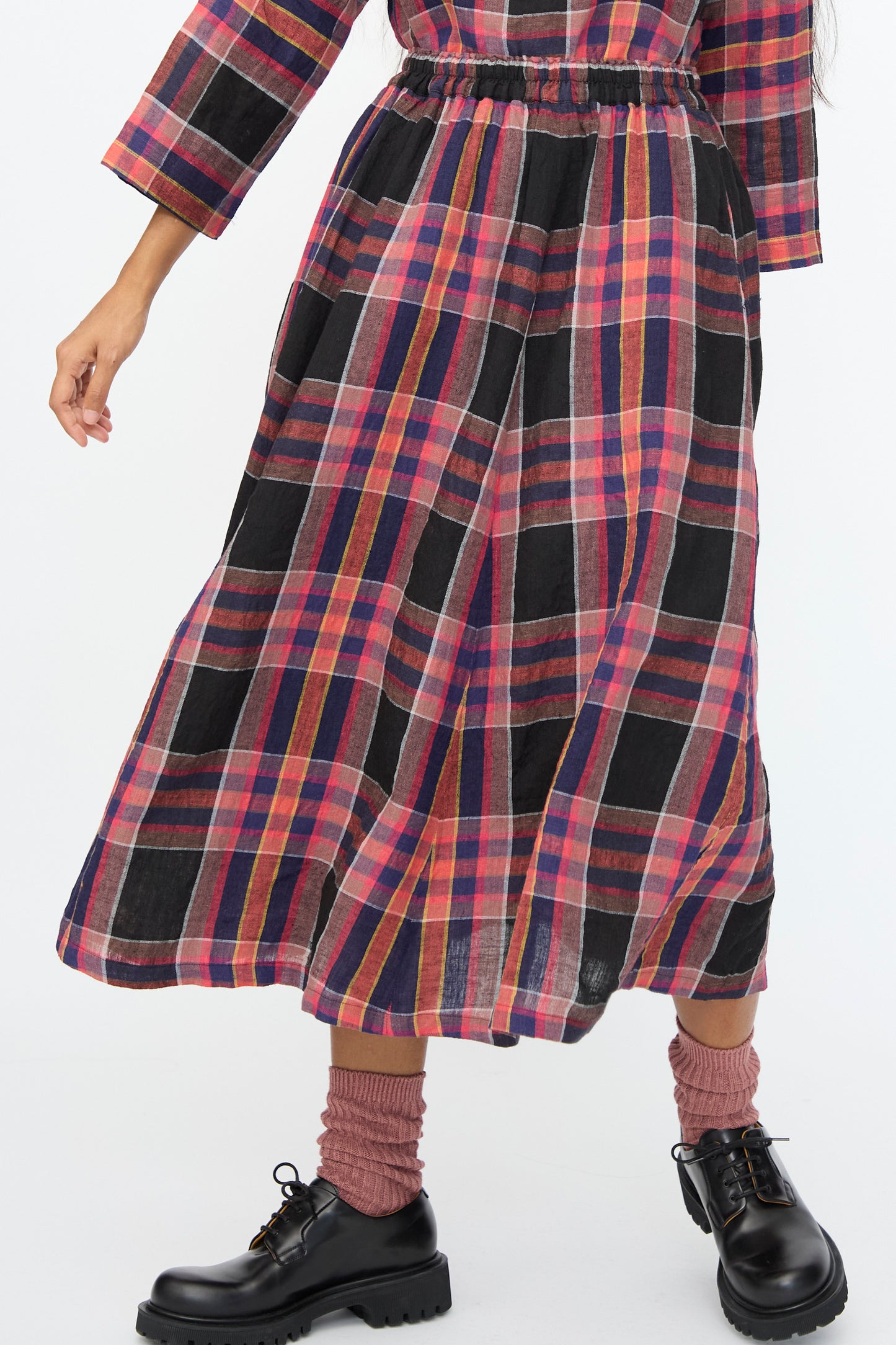 Model wearing the Ichi Antiquités Linen Check Skirt in Black, styled with pink socks and black lace-up shoes.