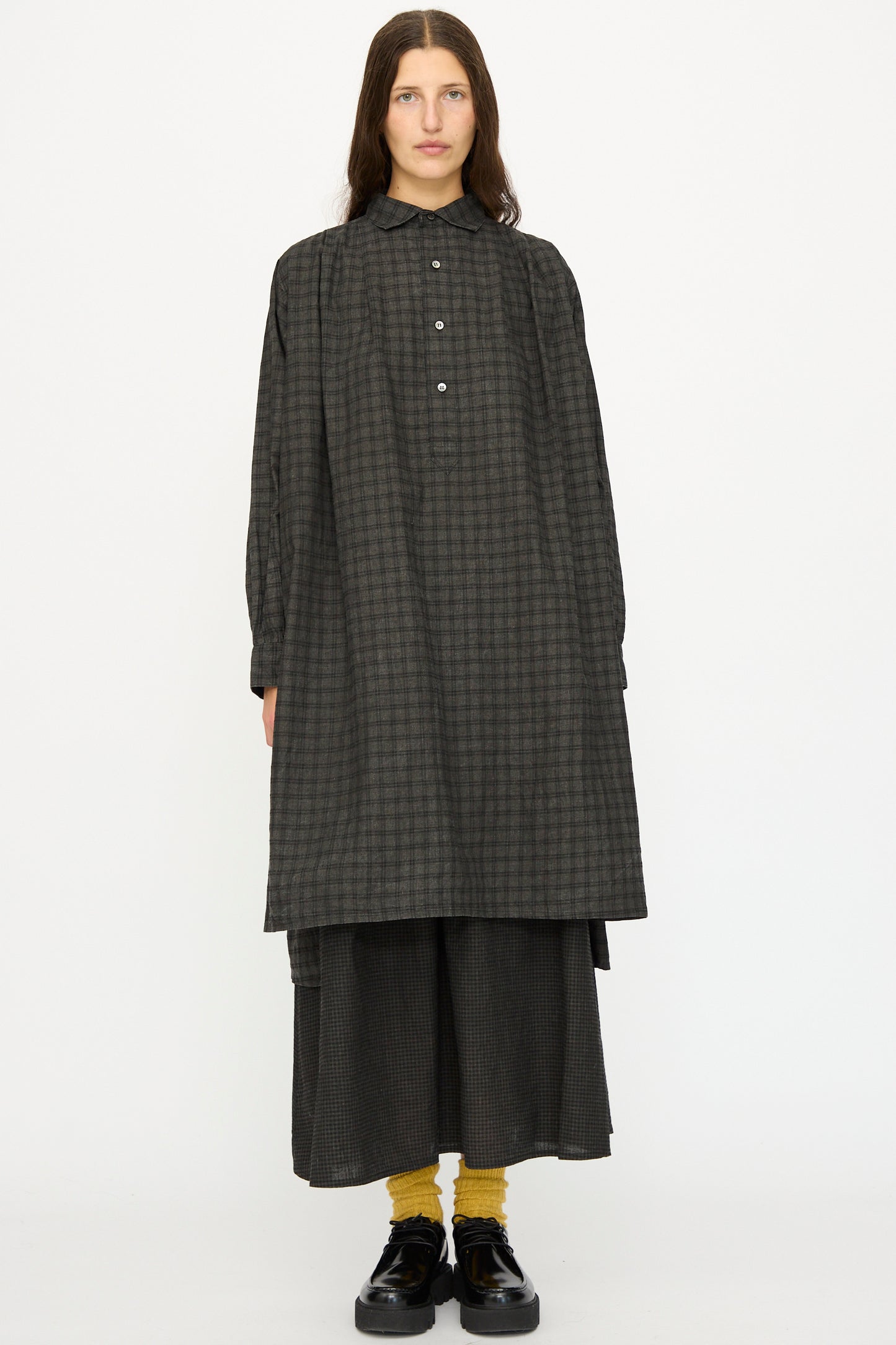 A person wears the Ichi Antiquités Linen Cotton Gingham Sumi Shirt in Pin Check over matching wide pants, with yellow socks and black shoes, standing against a plain white background.