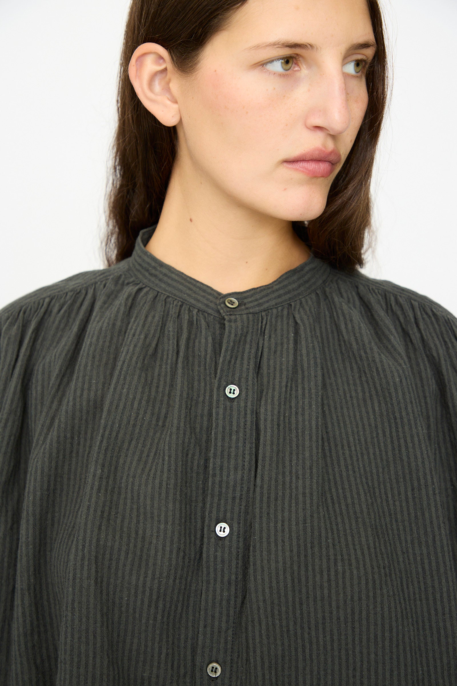 A person with long brown hair wears the Ichi Antiquités Linen and Cotton Stripe Shirt in Charcoal, looking slightly to the side against a plain background.