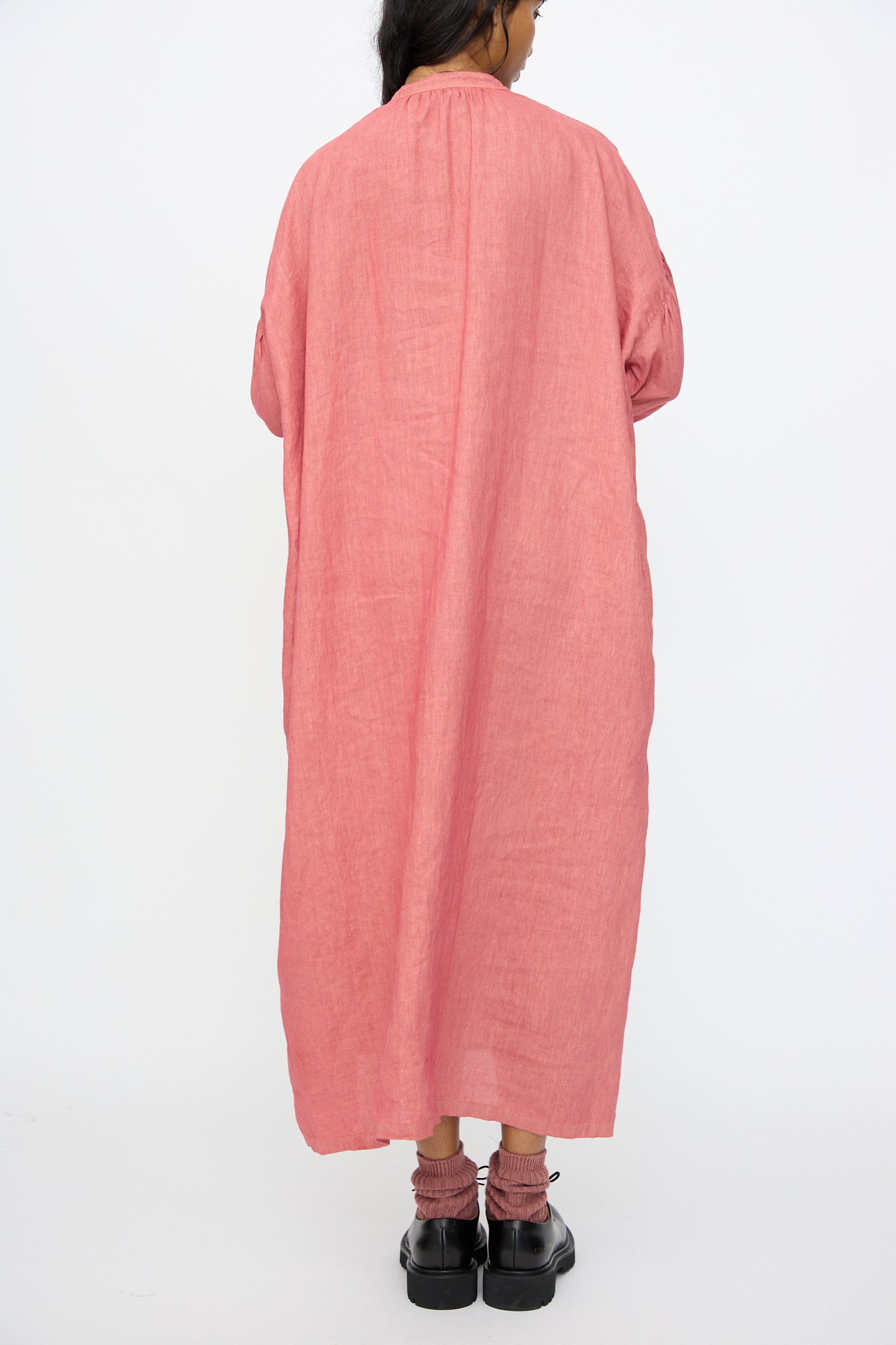 A person stands with their back to the camera wearing the Ichi Antiquités Linen Dress in Pink, paired with black platform sandals, against a plain white background.