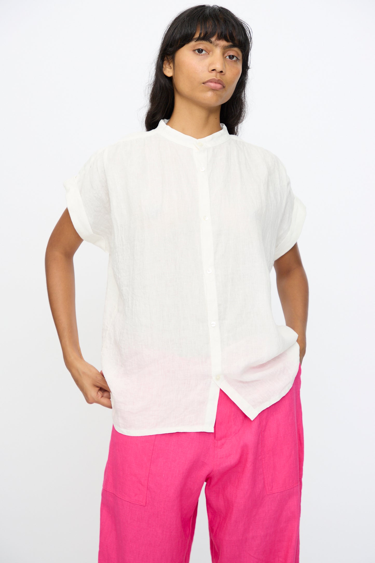 A person models the Ichi Antiquités Linen Dungaree Blouse in White with bright pink pants, standing against a plain white background.