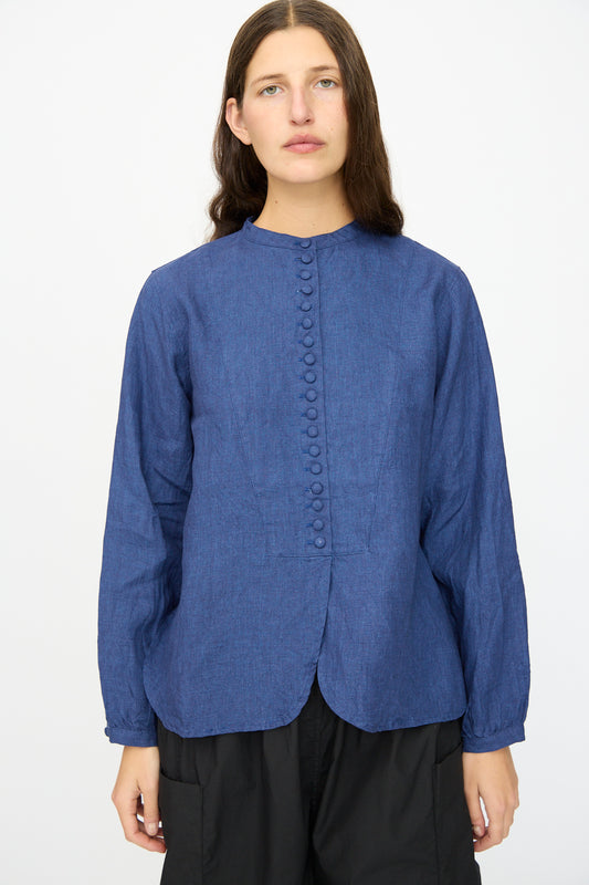 A person with long brown hair wears the Linen Shirt in Indigo by Ichi Antiquités and black pants, standing against a plain white background.