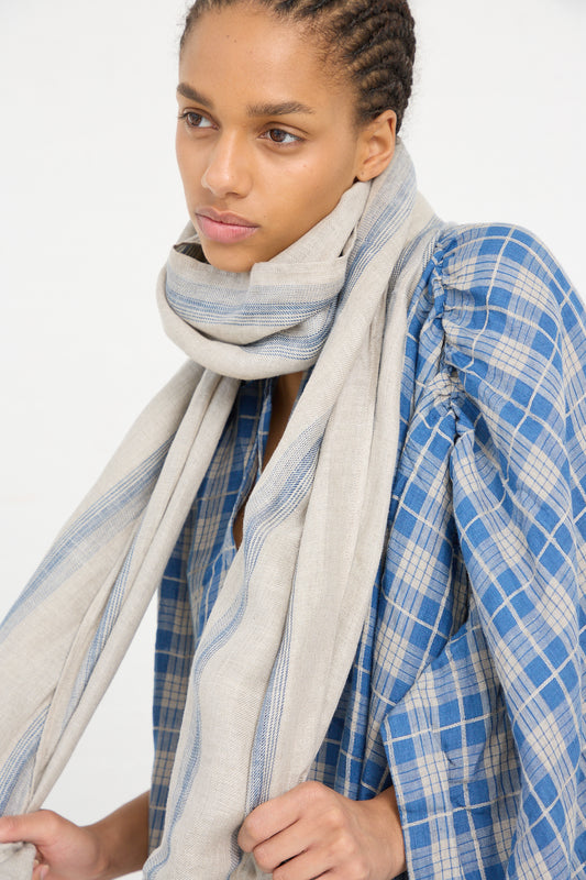 Woman wearing a plaid garment and an Ichi Antiquités Linen Stripe Stole in Natural and Indigo.