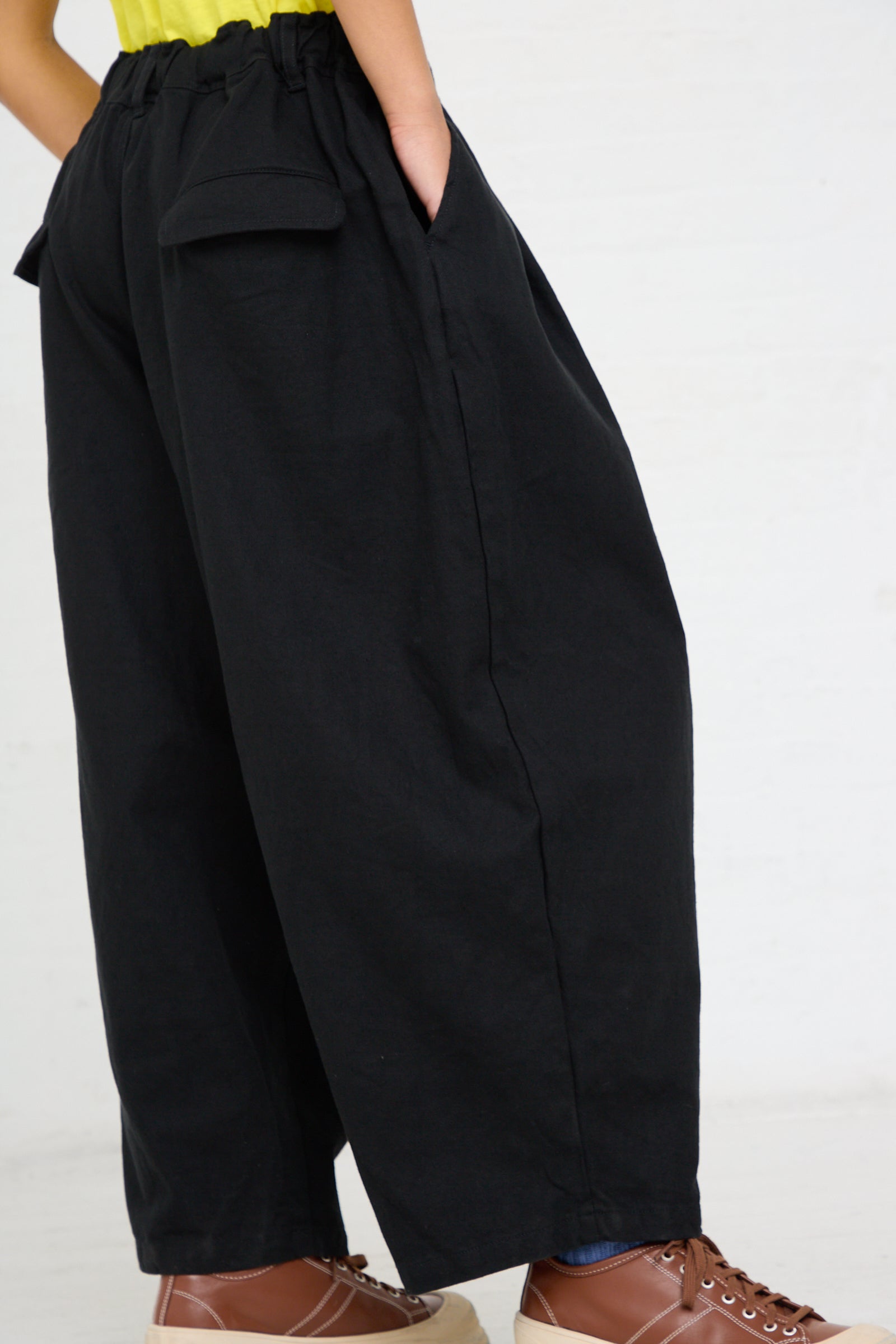 A person wearing the Woven Cotton Linen Pant in Black by Ichi Antiquités and brown lace-up shoes.