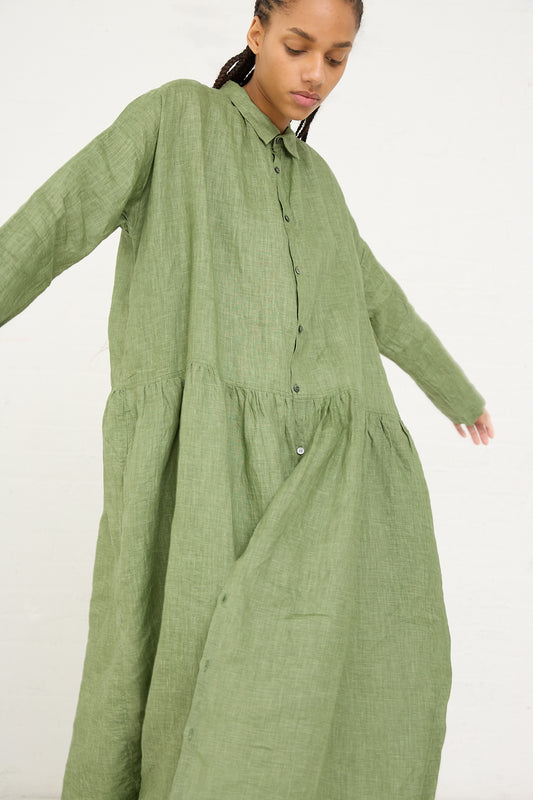 A woman in an oversized, pigment-dyed Ichi Antiquités linen dress with pockets, mid-movement against a white background.