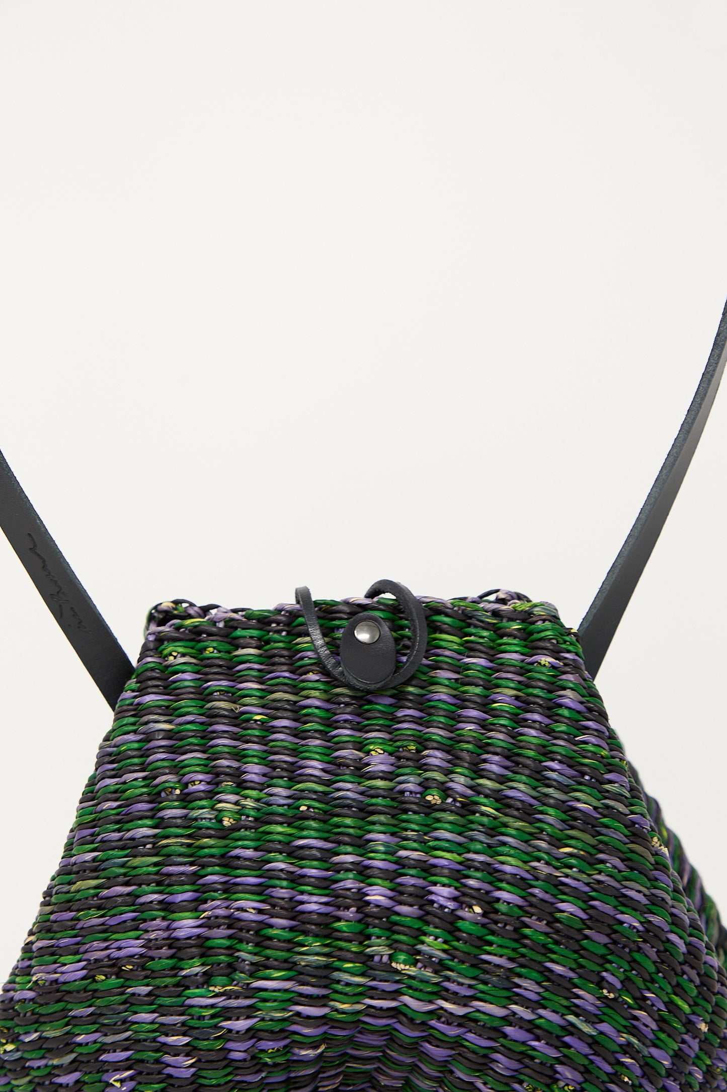Close-up of a textured, multicolored Inès Bressand N. 14 Mini Shell Bag in Green shoulder bag with black straps against a white background.