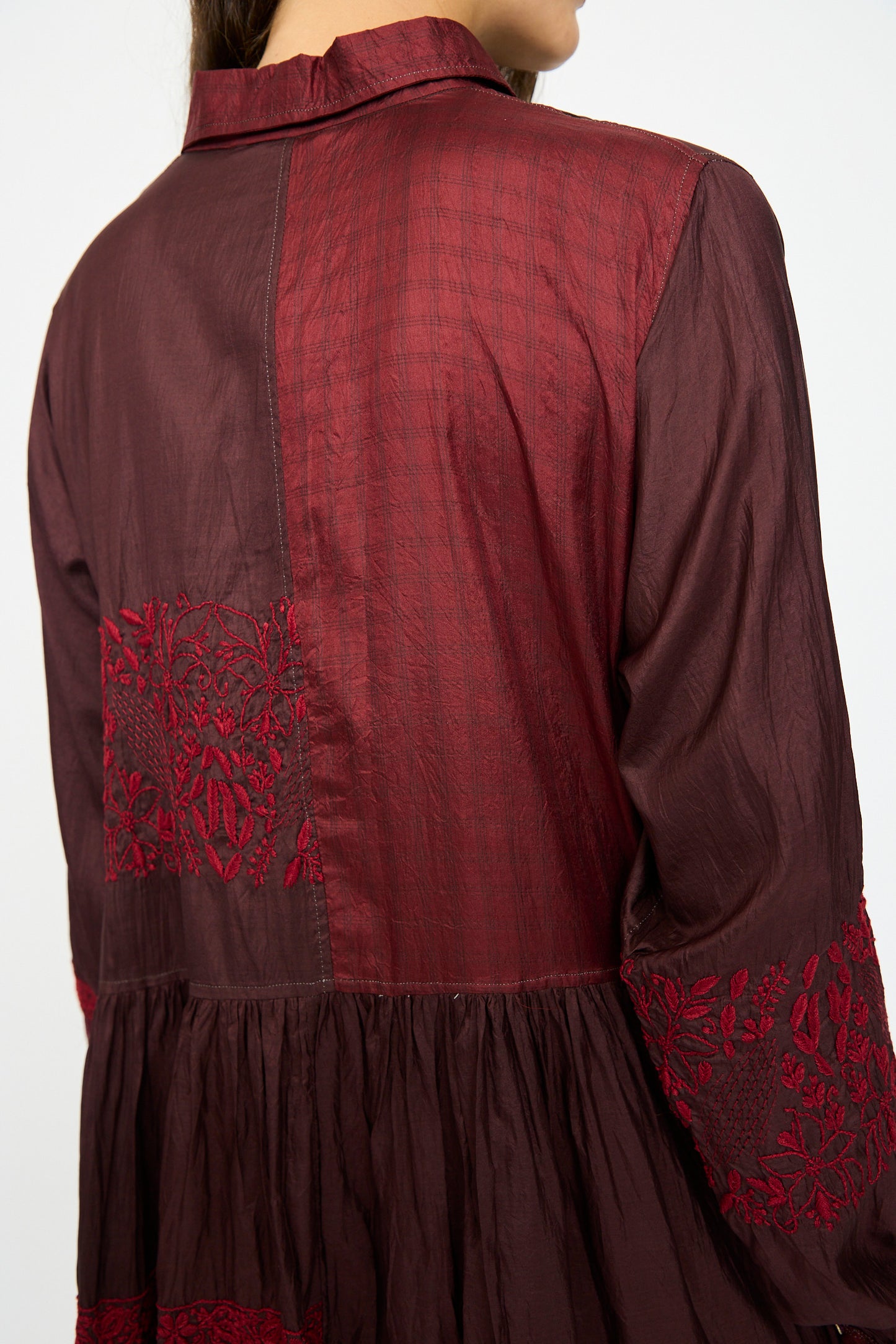 A person wears the Injiri Silk and Cotton Dress in Red, shown from the back and slightly turned to the side.
