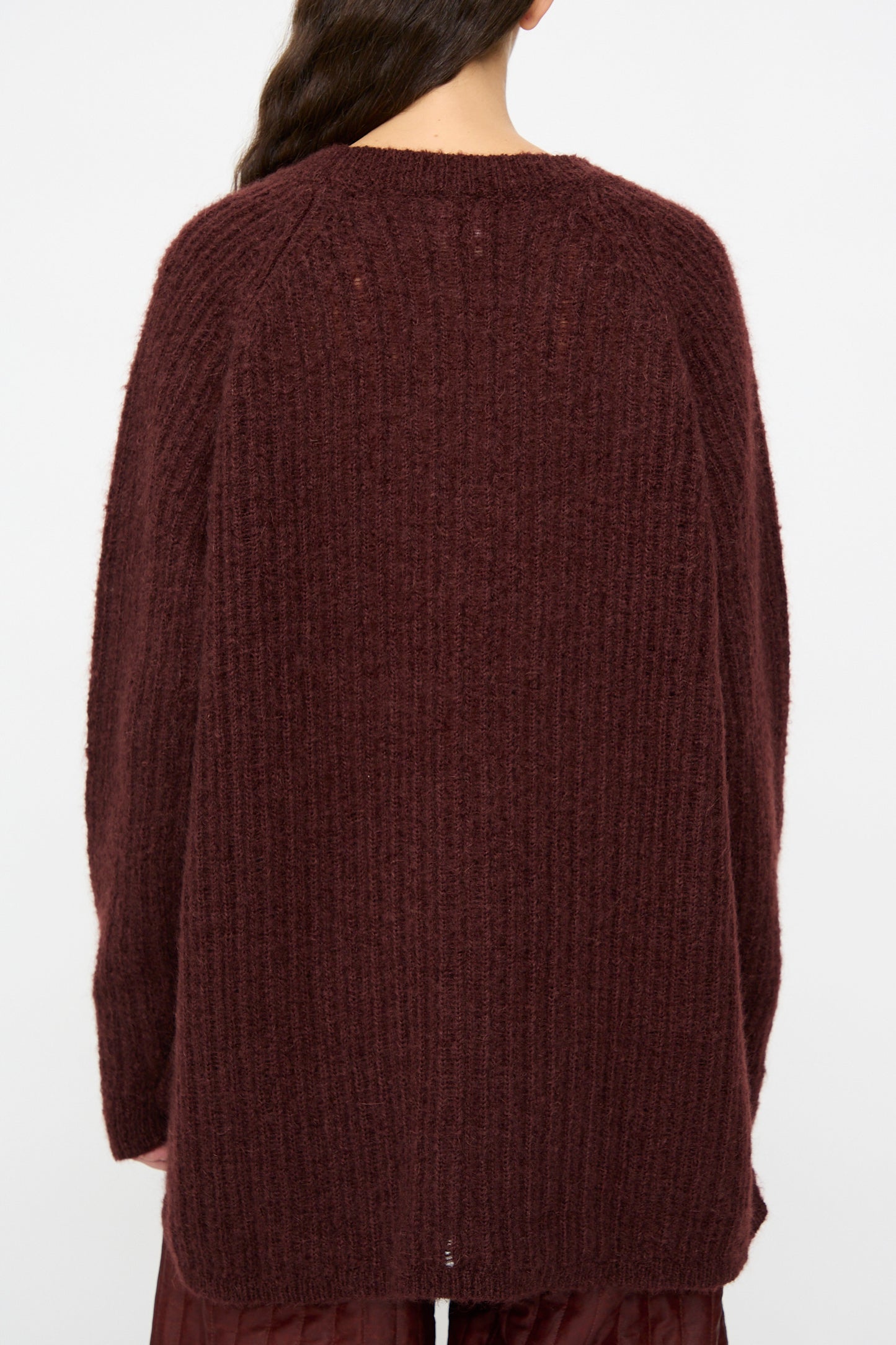 Model wears the Jan-Jan Van Essche Mohair Knit #71 Sweater in Oxblood, featuring an oversized fit, long sleeves, and a ribbed maroon texture, shown from the back against a plain background.