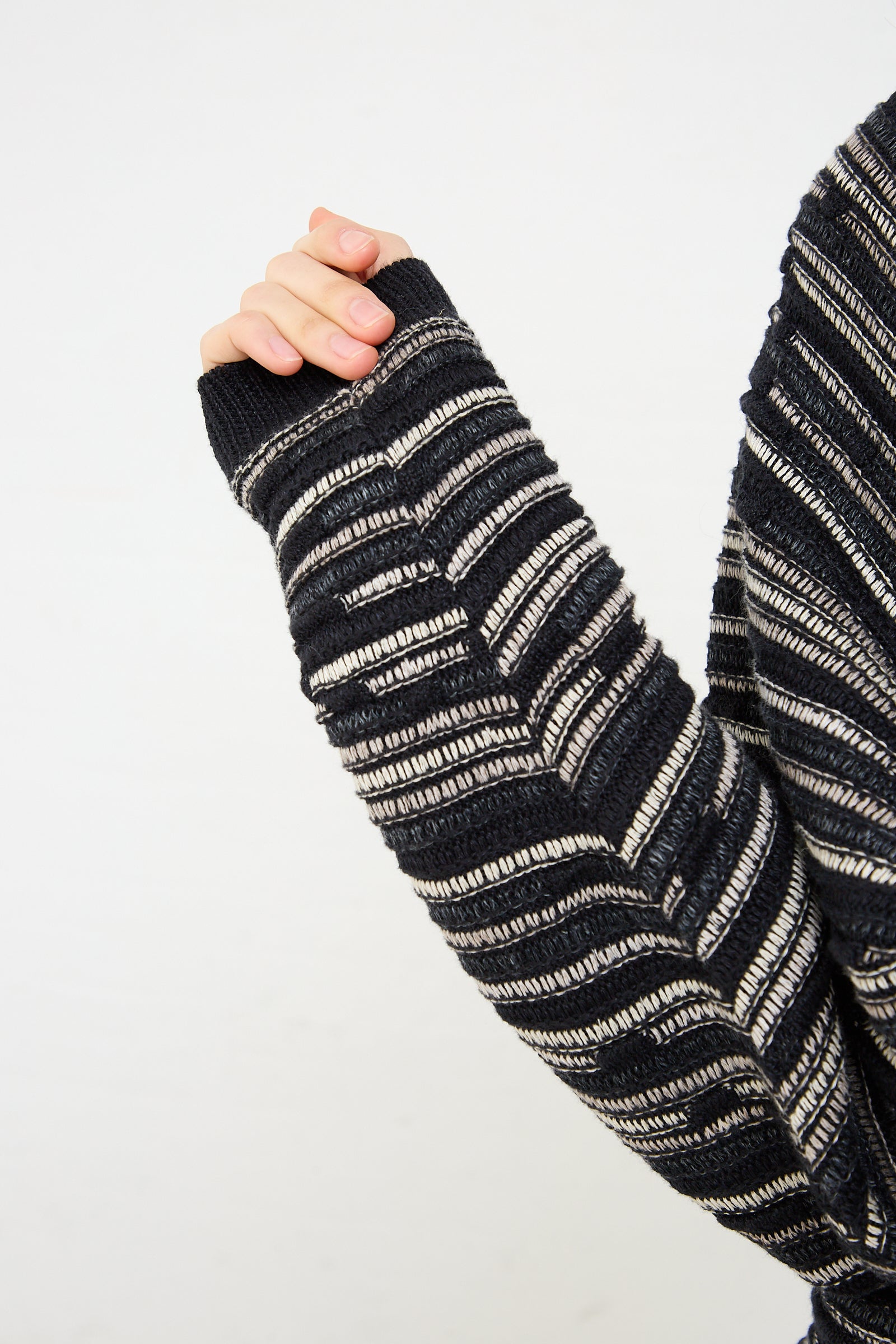 A woman wearing a Jan-Jan Van Essche Linen Cotton Knit Crewneck in Black. Up close view of sleeve.